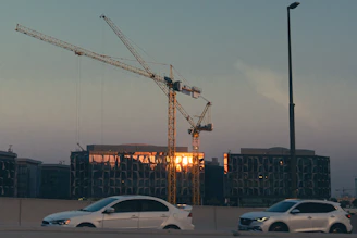 Construction cranes and buildings at sunset