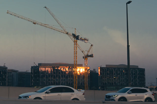 Construction cranes and buildings at sunset