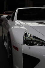 White sports car with sleek headlights and spoiler.