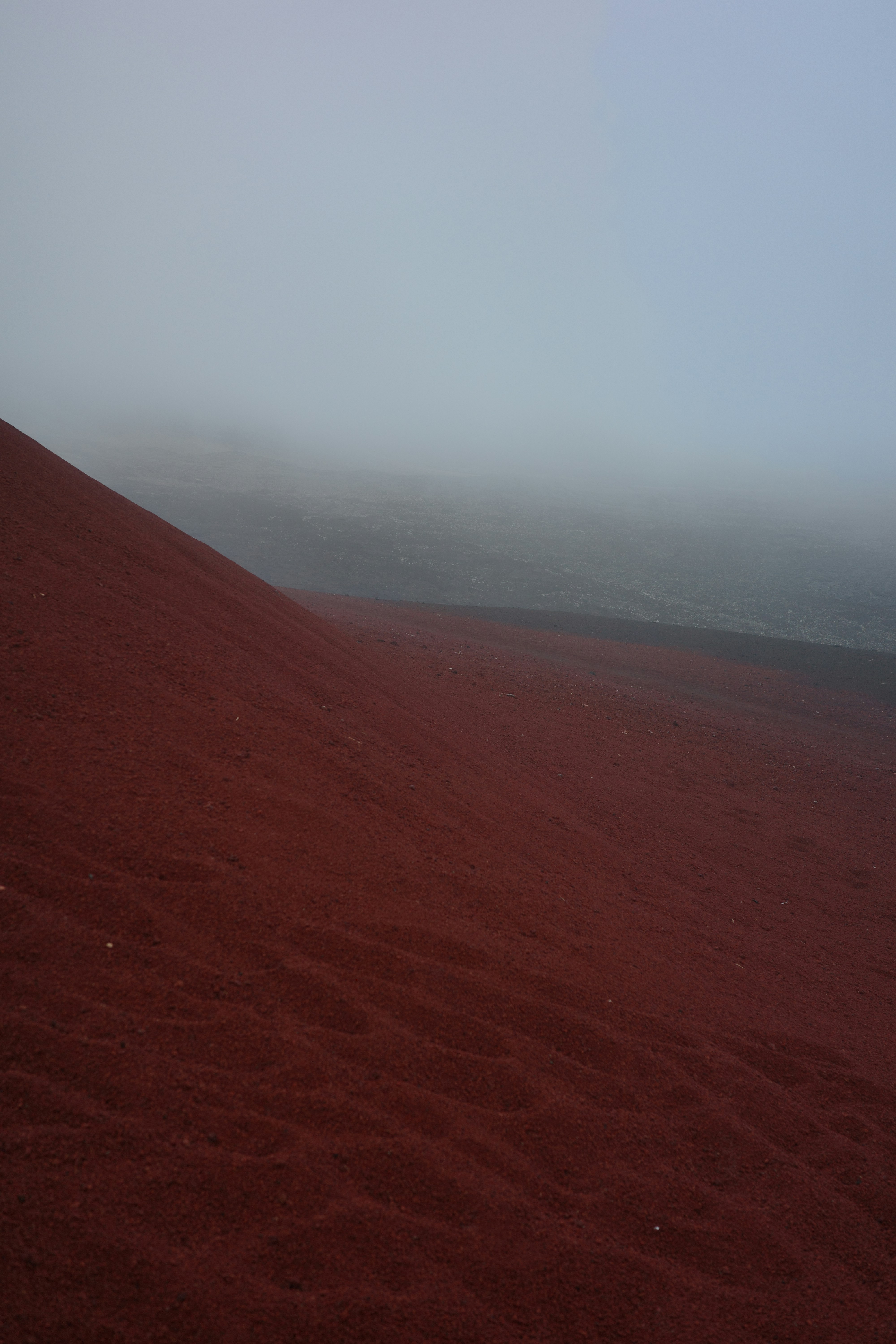 Red sand dune slopes in thick fog