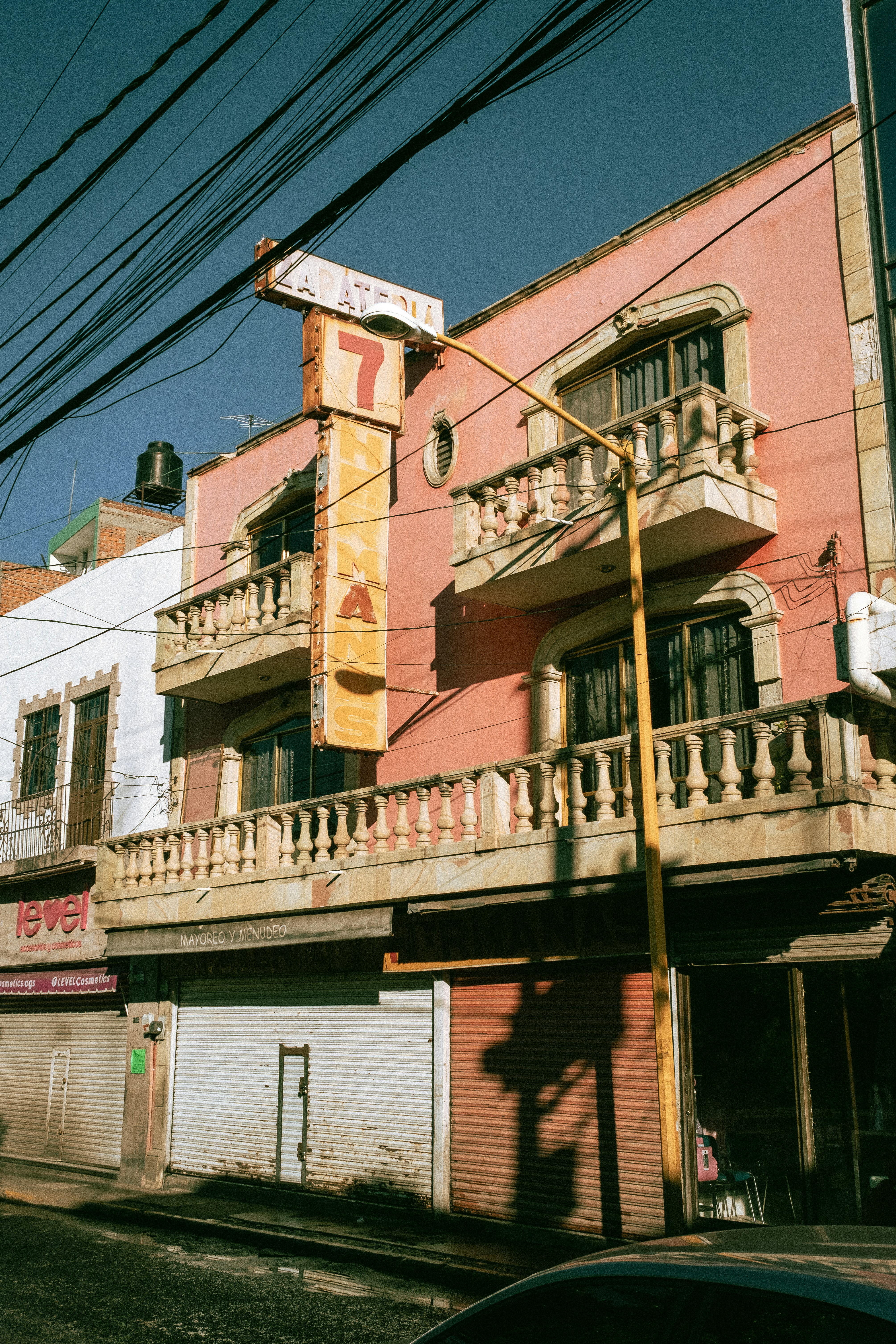 Pink building with balconies and a sign
