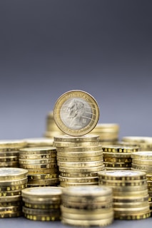 Stacks of gold coins with one coin on top