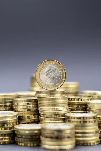 Stacks of gold coins with one coin on top