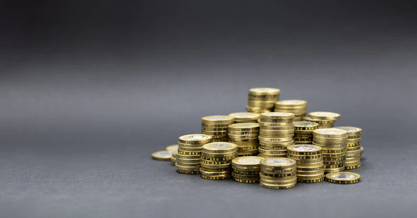 A pile of gold coins on a dark background