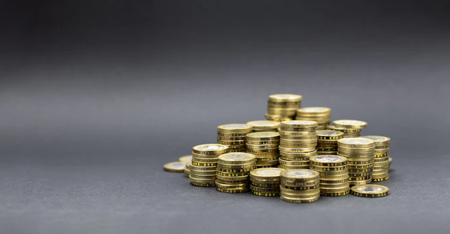A pile of gold coins on a dark background