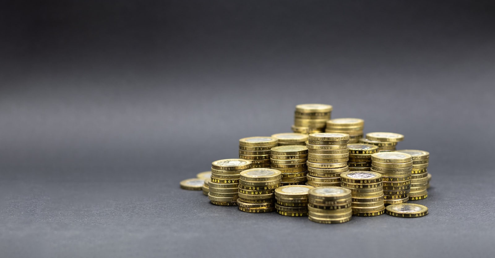 暗い背景に置かれた金色の硬貨の山