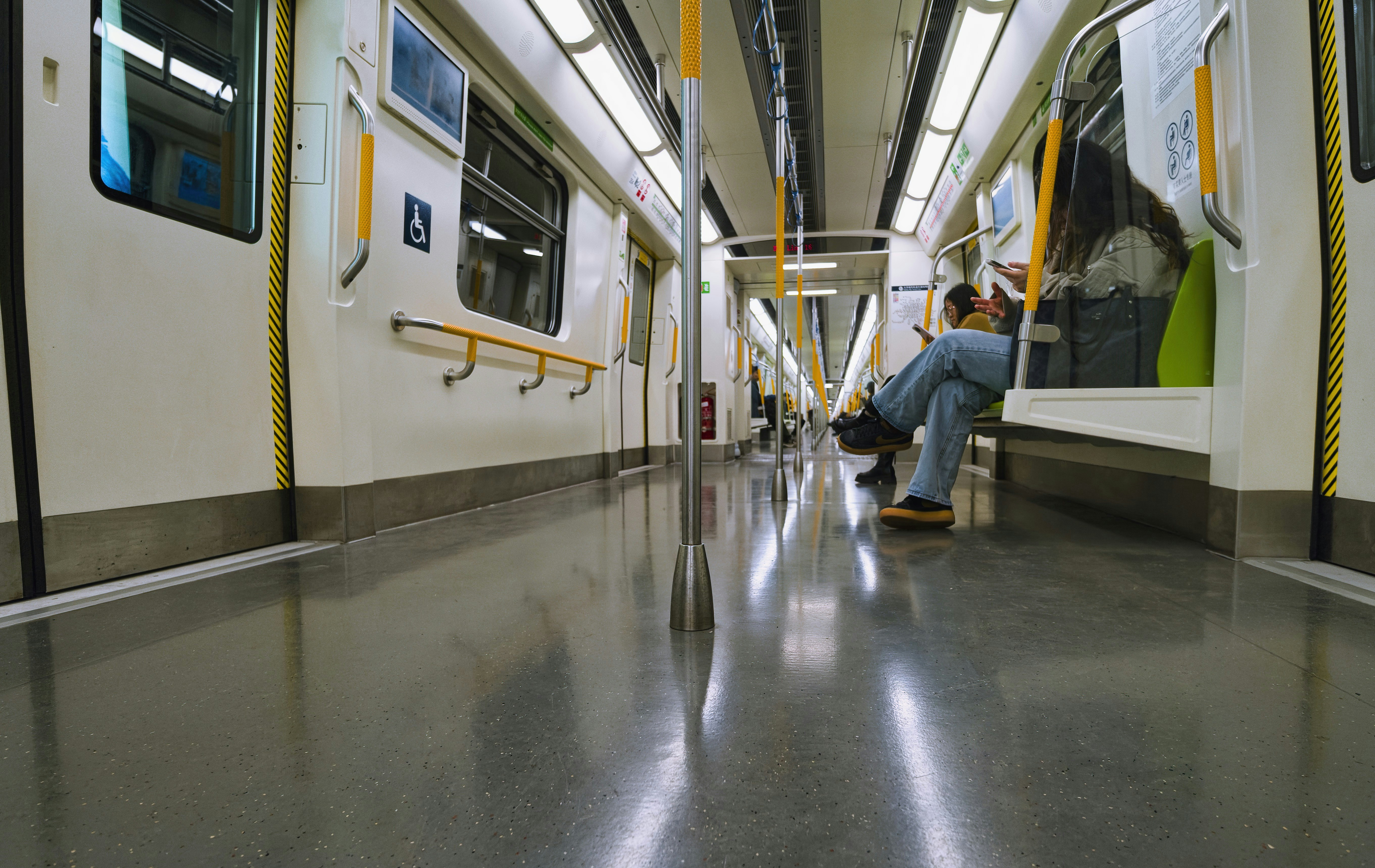 Empty subway car interior with one passenger sitting.