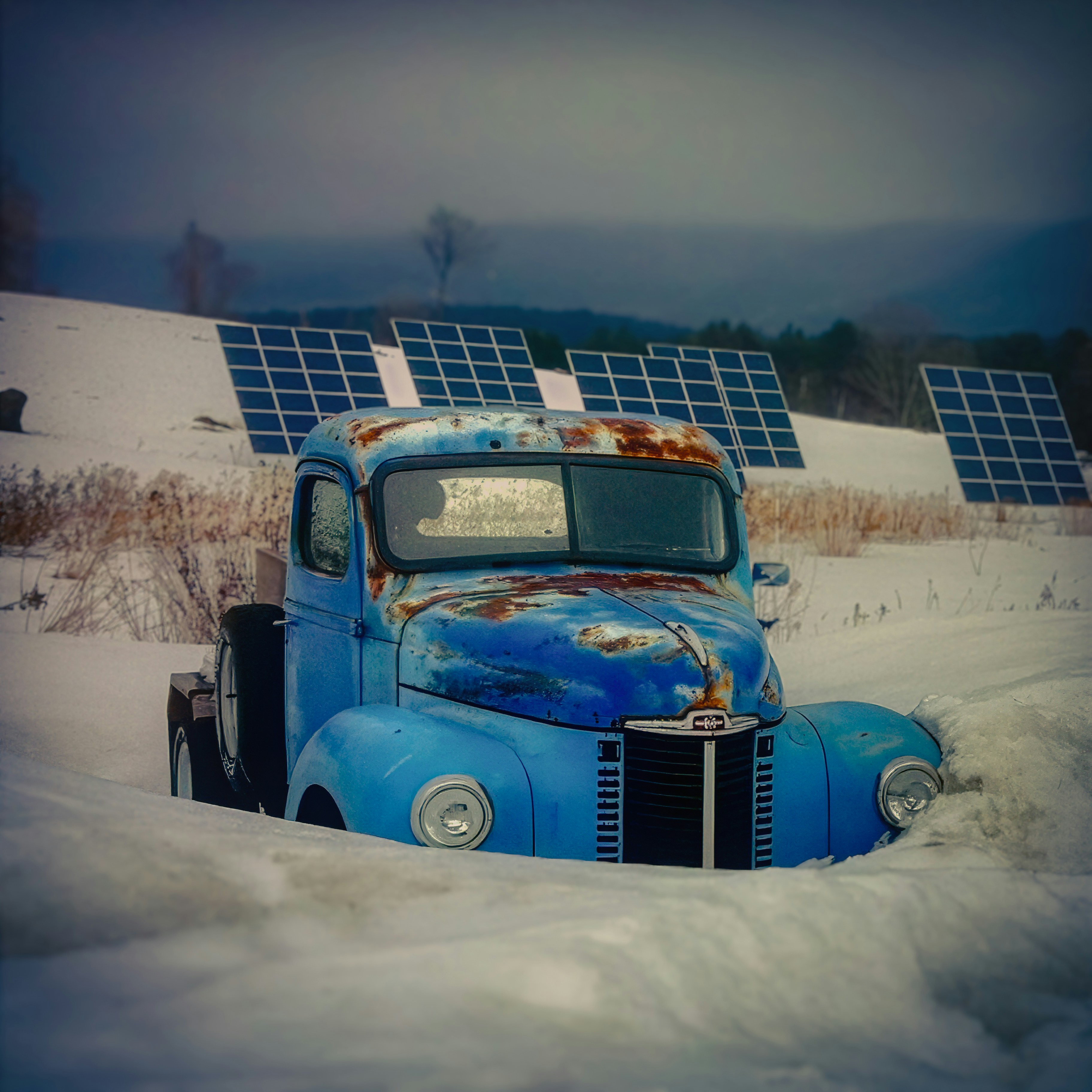 Viejo camión azul atascado en la nieve con paneles solares.