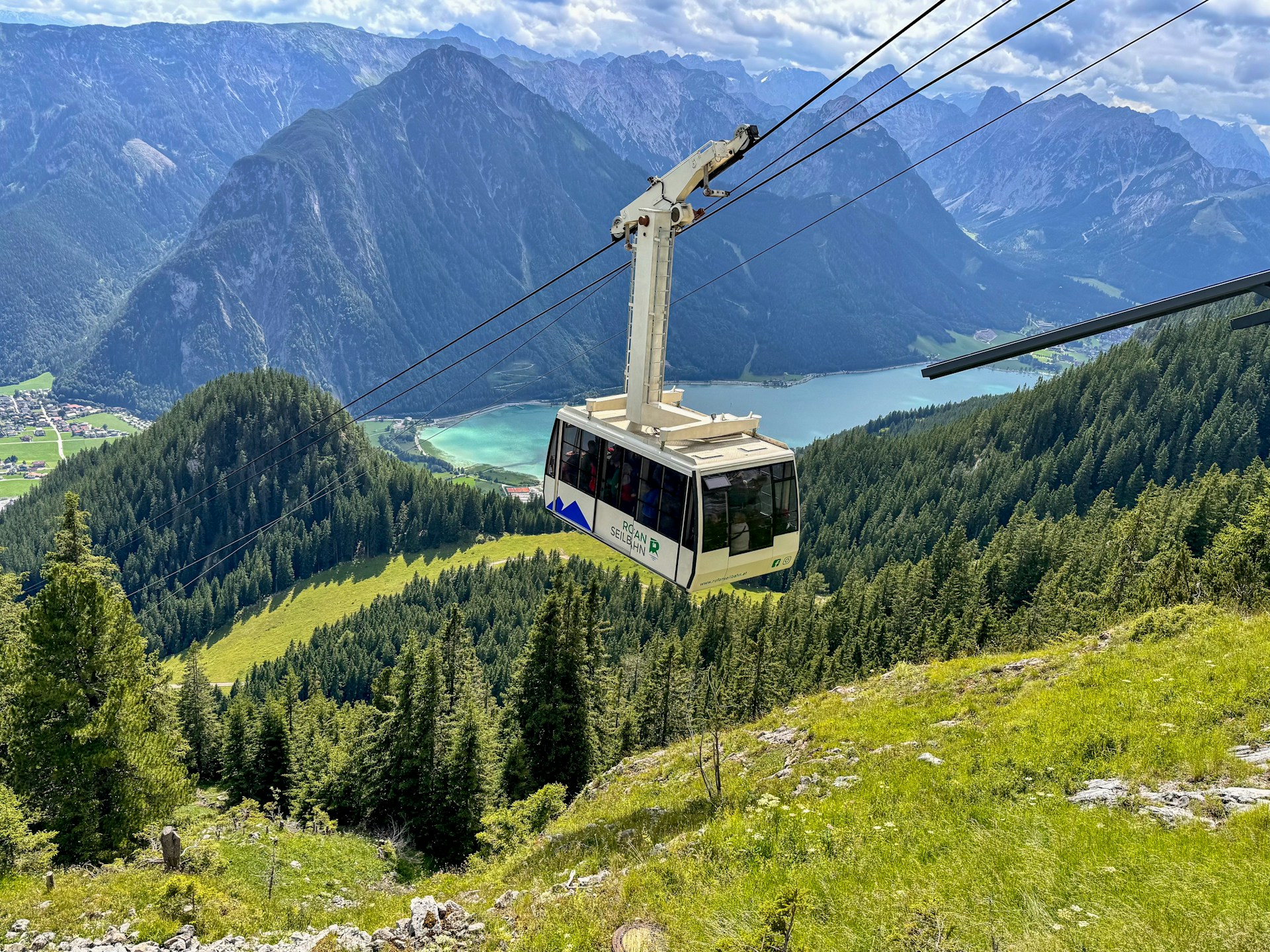 Cable car ascends mountain with lake view