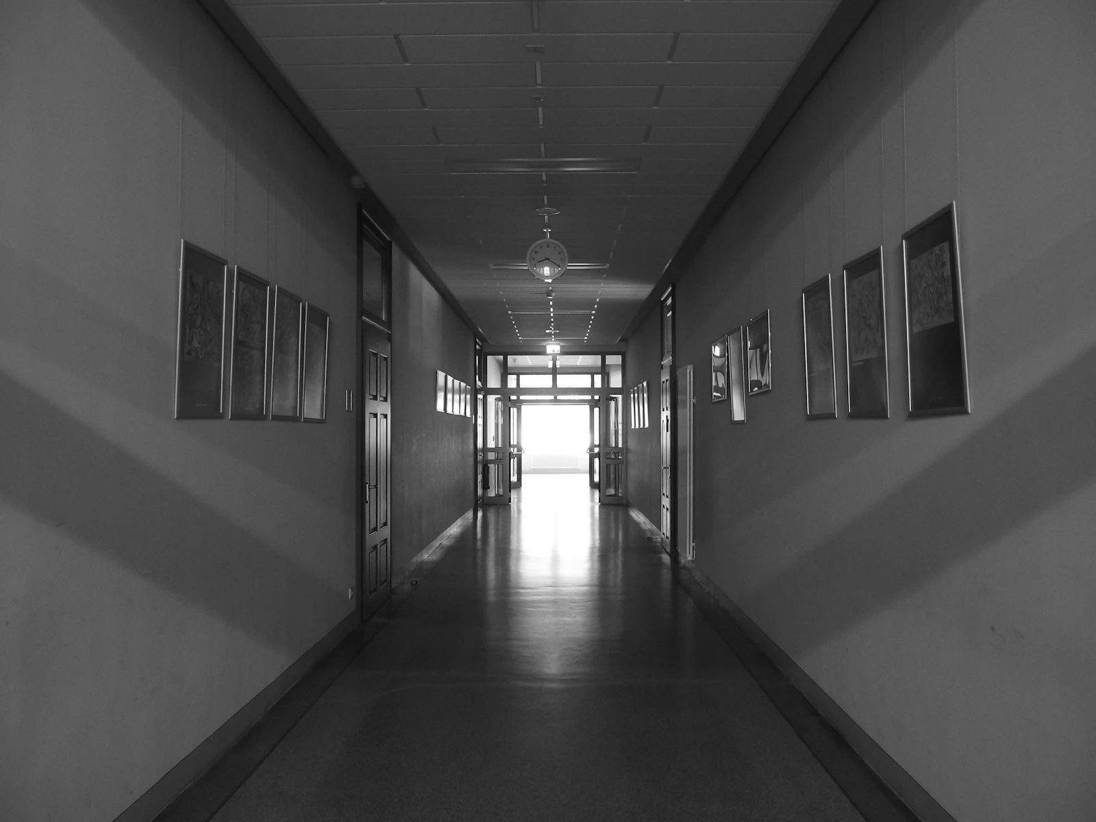 Long, empty school hallway with doors and windows
