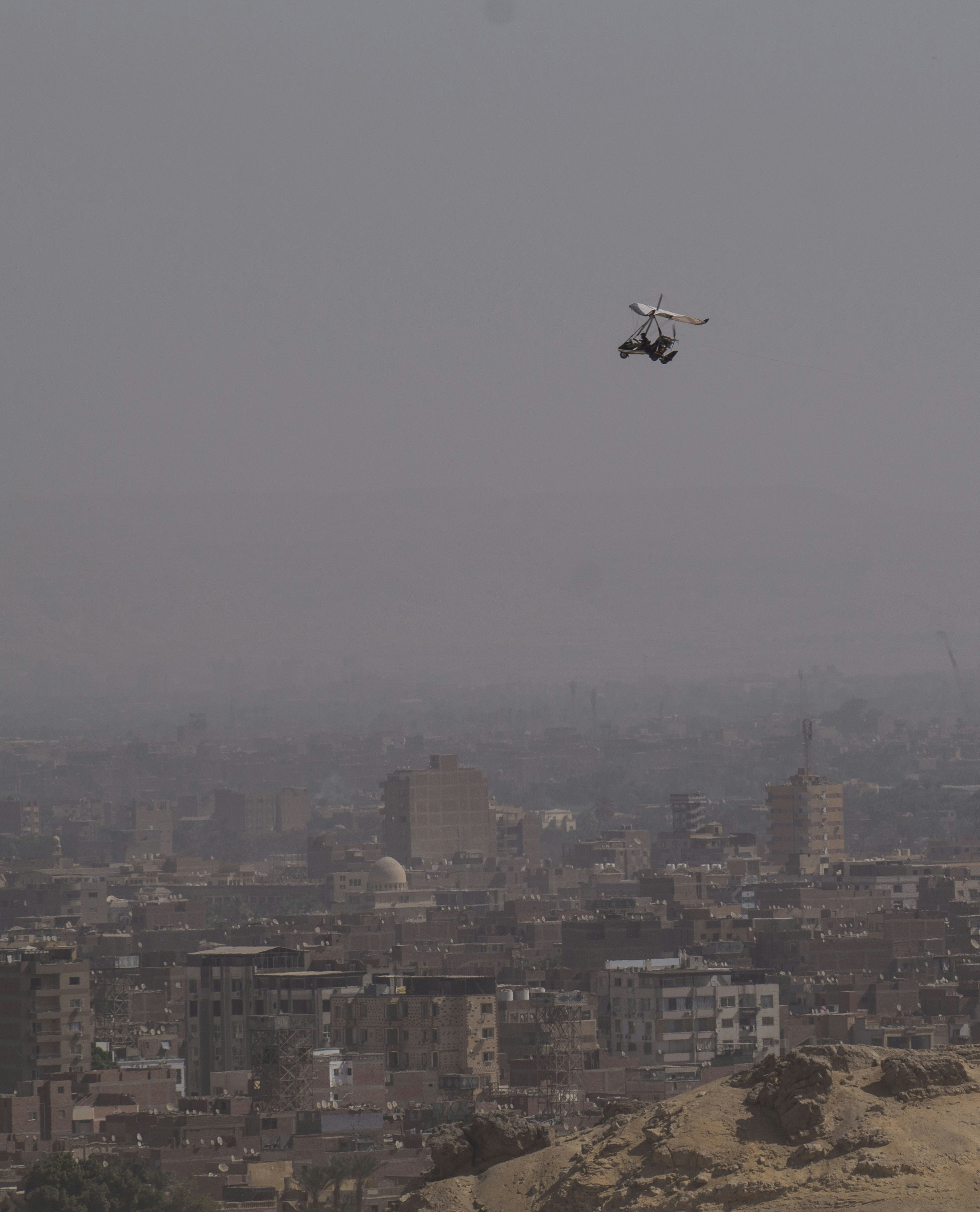 Drone flying over a hazy cityscape with a city below