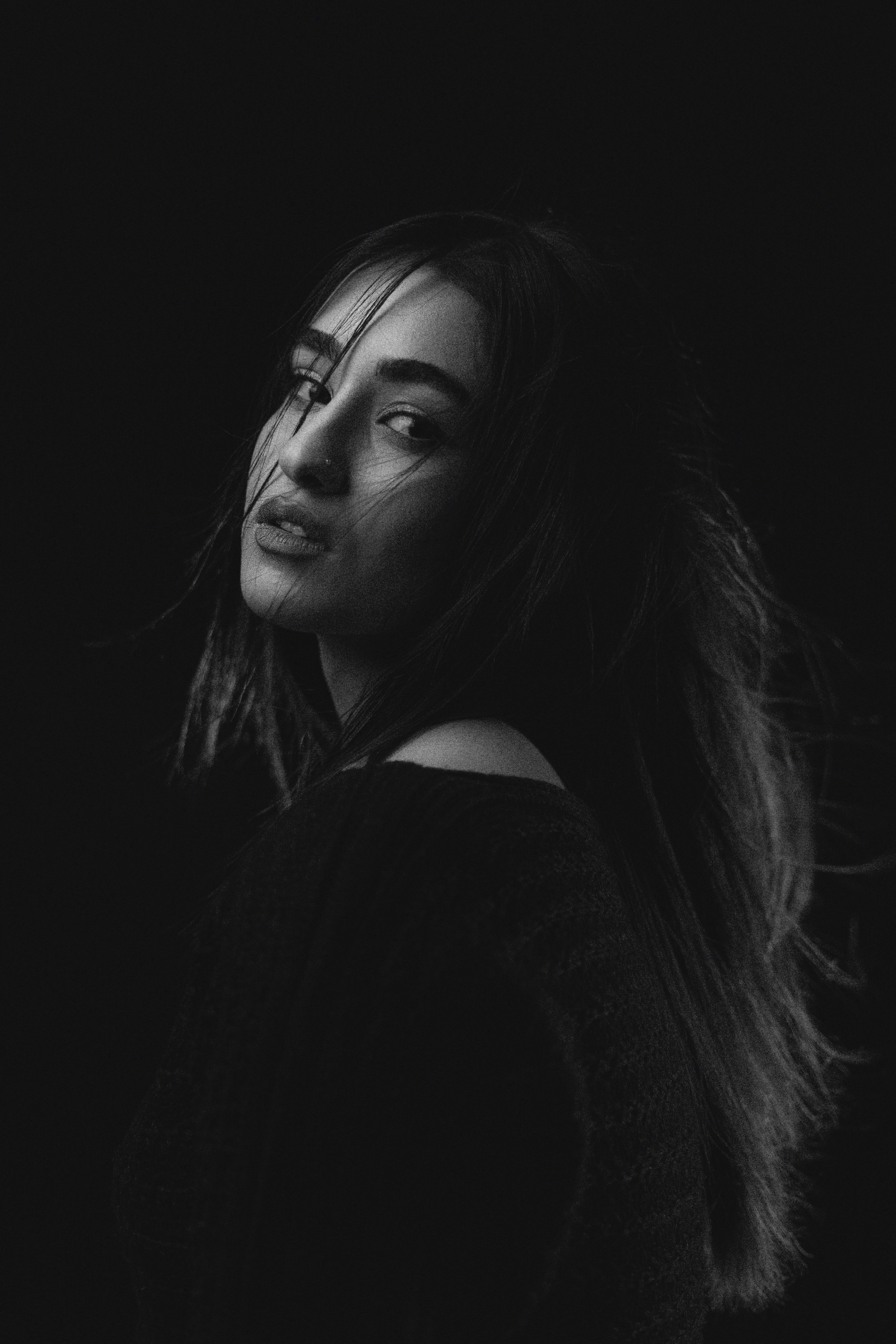 A woman with windswept hair looks over her shoulder.