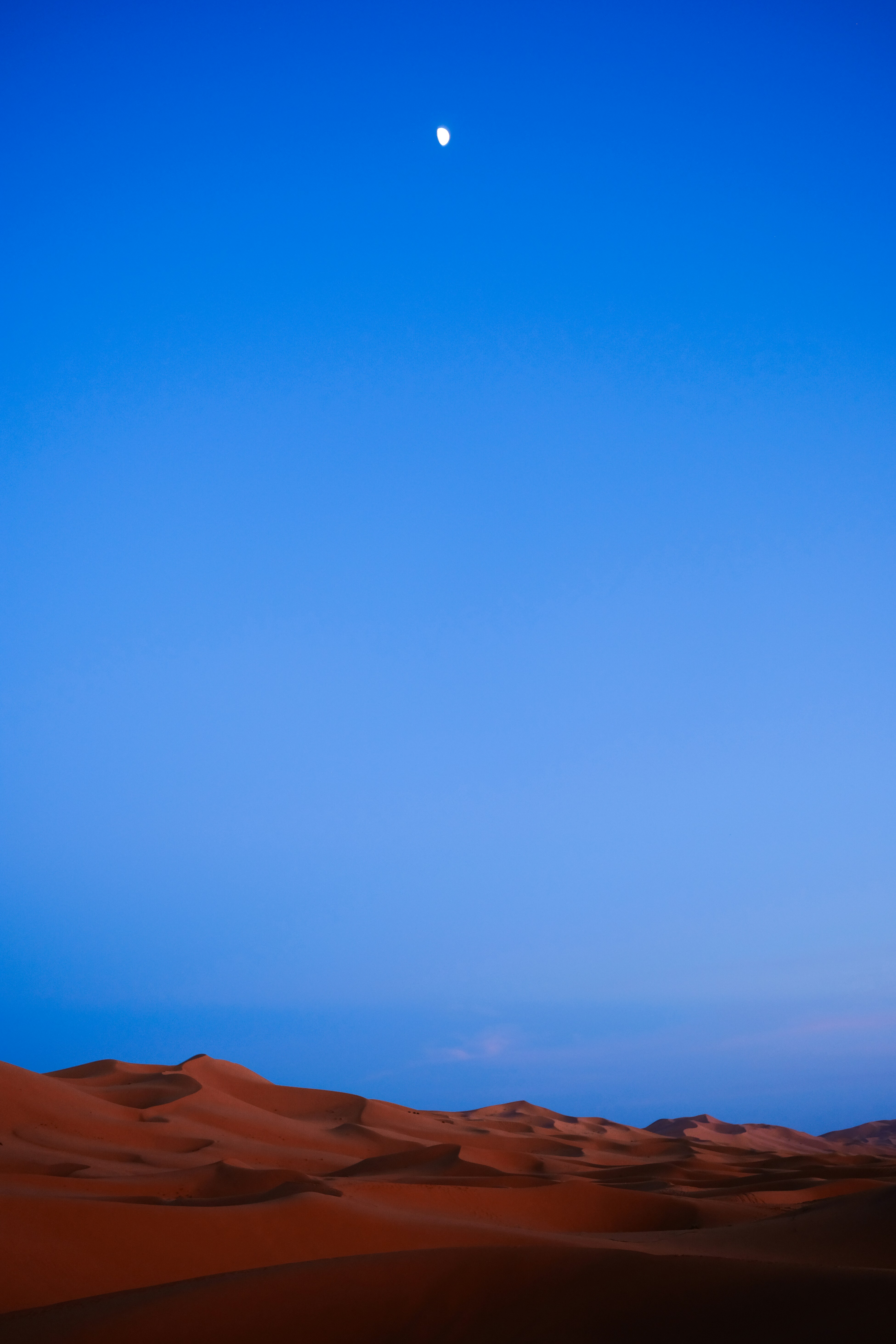 Des dunes de sable du désert au clair de lune sous un vaste ciel bleu