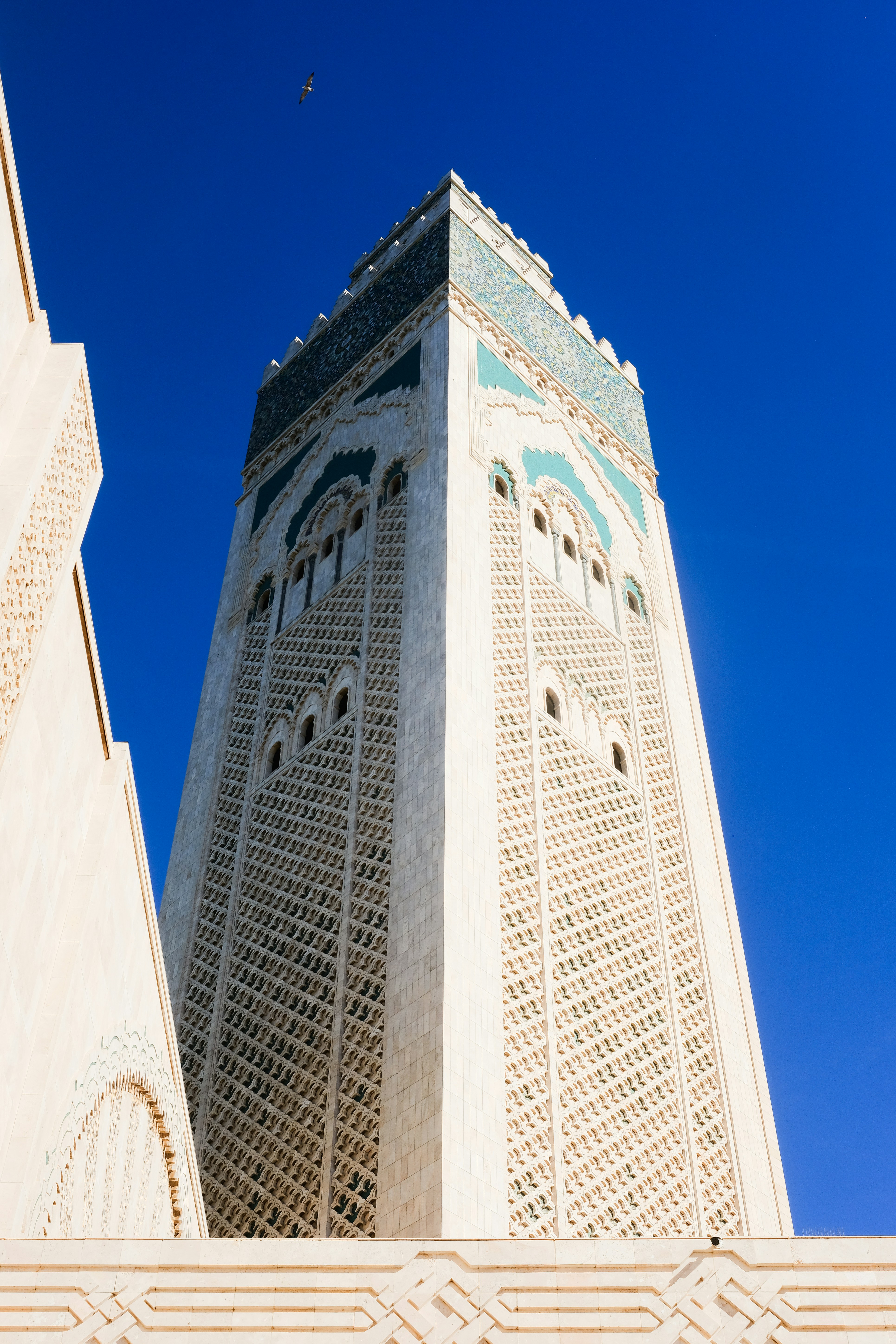 Tall minaret of a mosque against a clear blue sky.