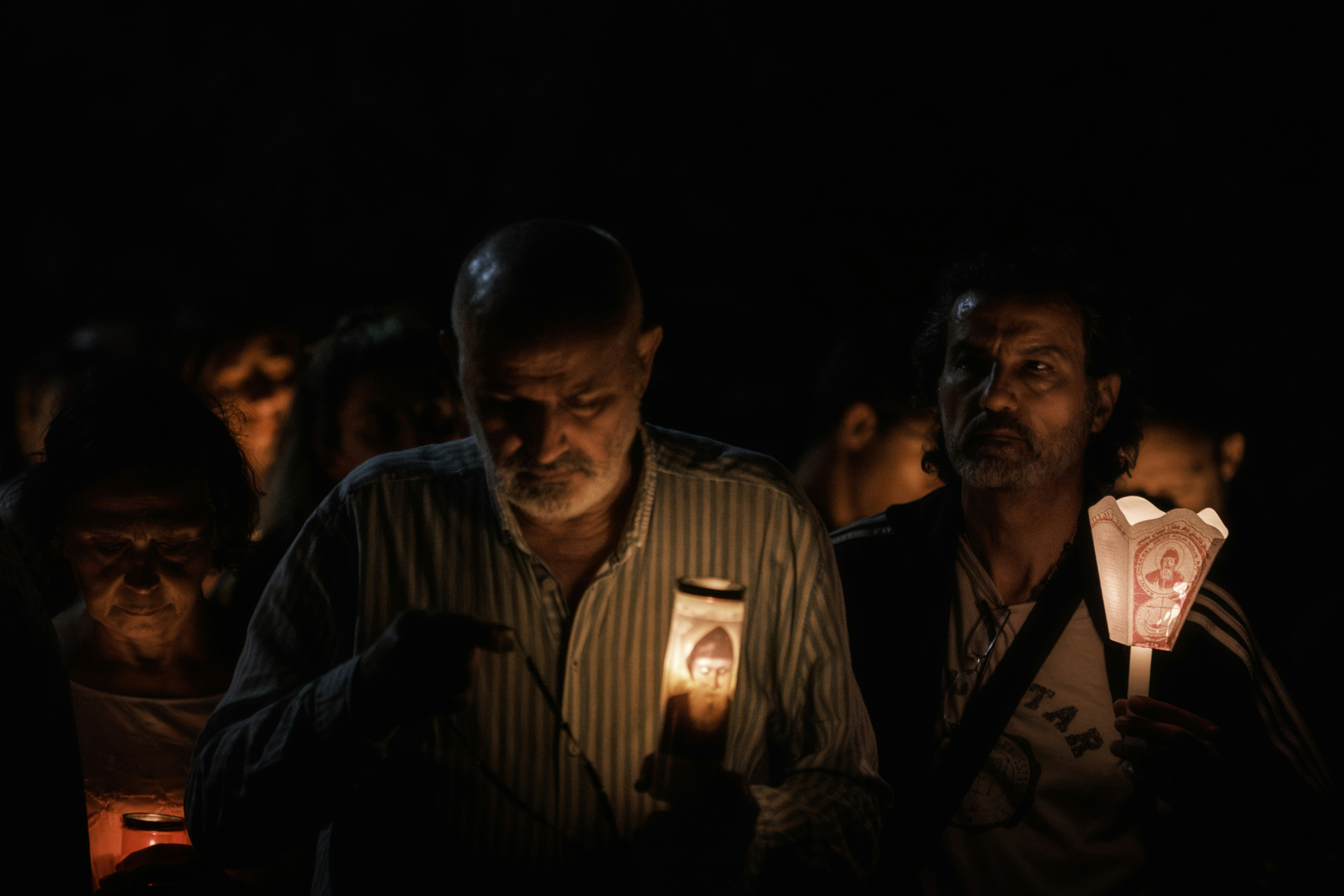 People holding candles in the dark