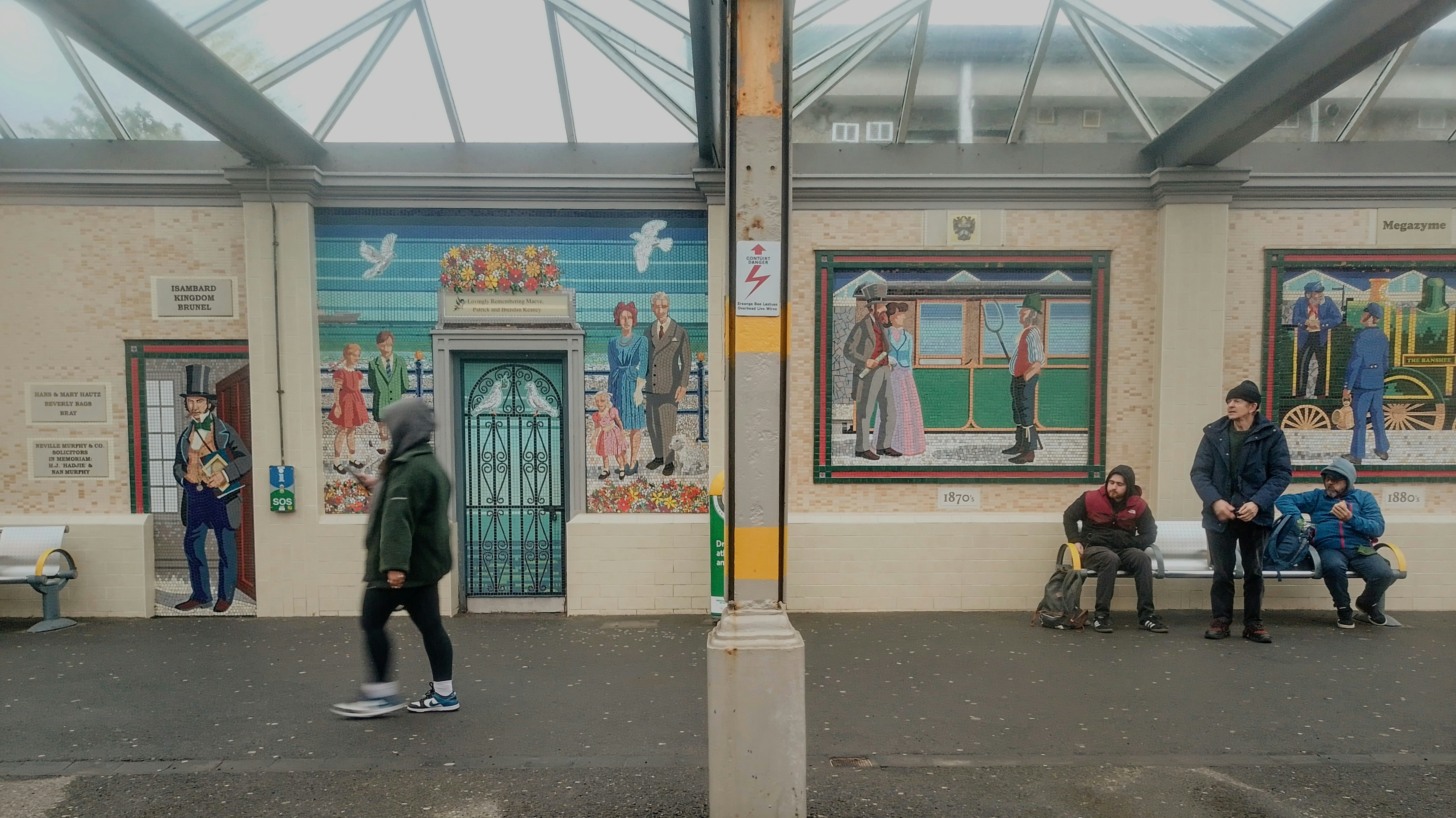 People waiting at a mural-adorned bus stop