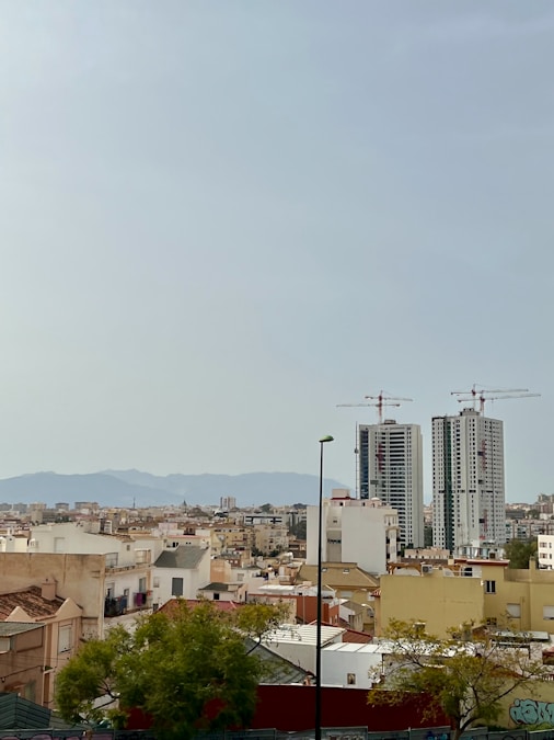 City skyline with construction cranes on tall buildings, representing downtown redevelopment