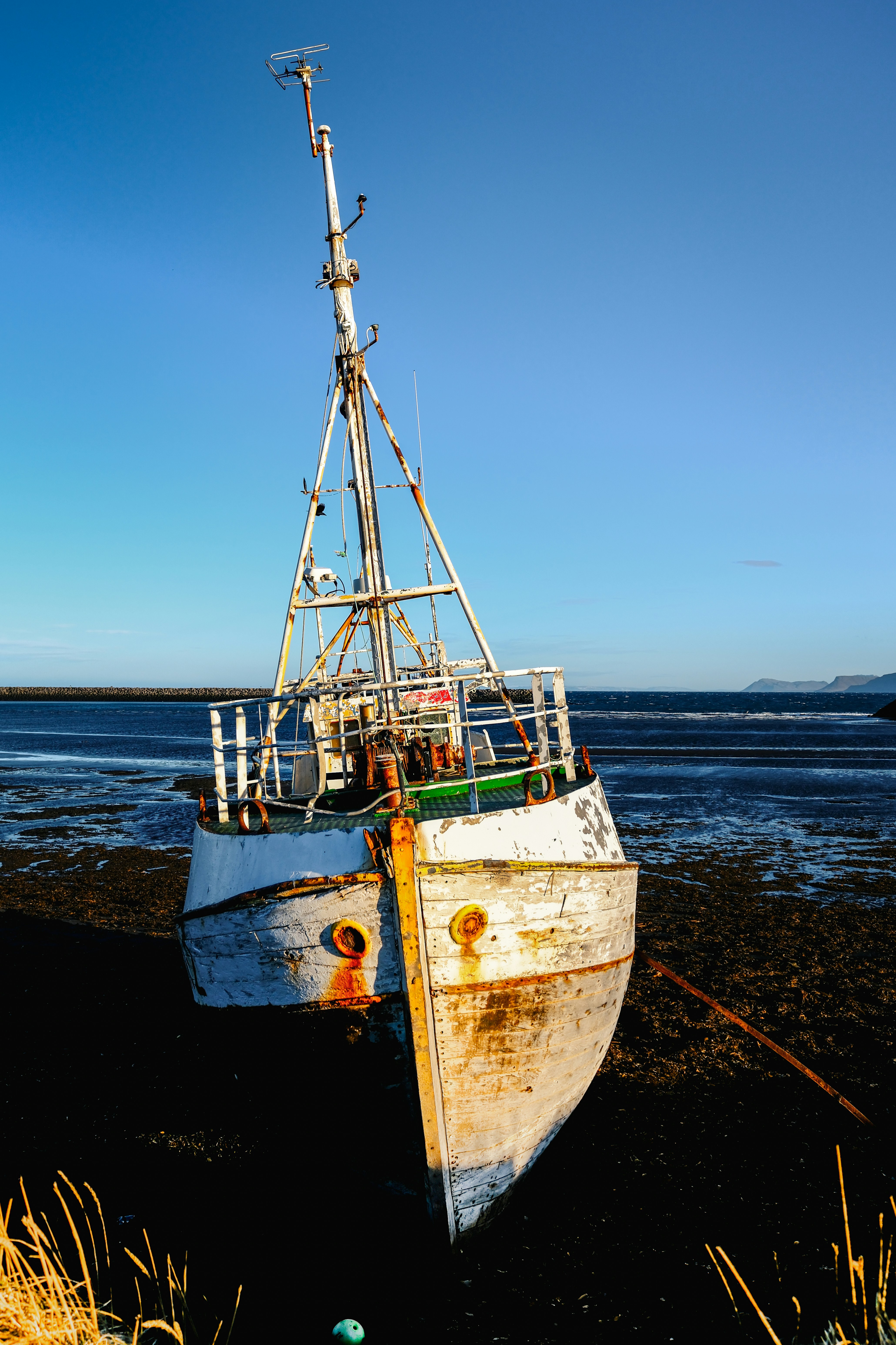 Old fishing boat grounded on a rocky shore