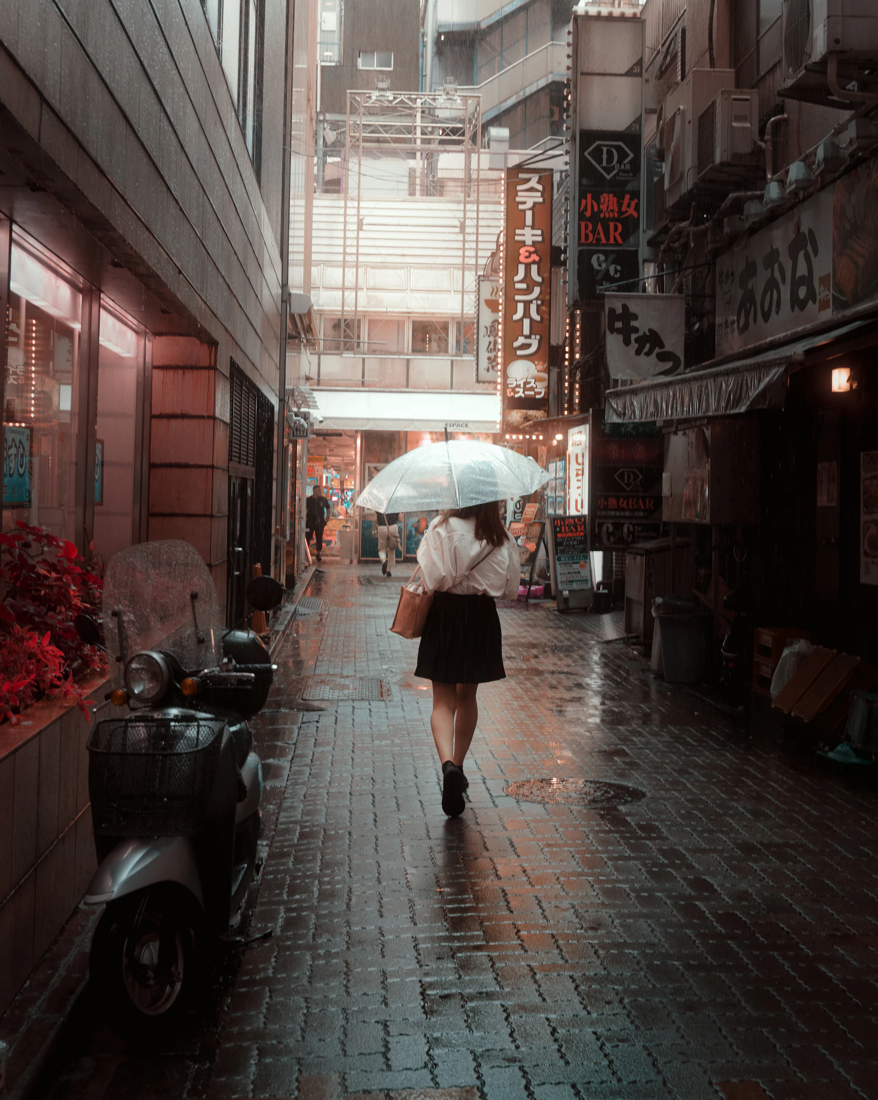 Une femme marche sous la pluie dans une ville en mouvement