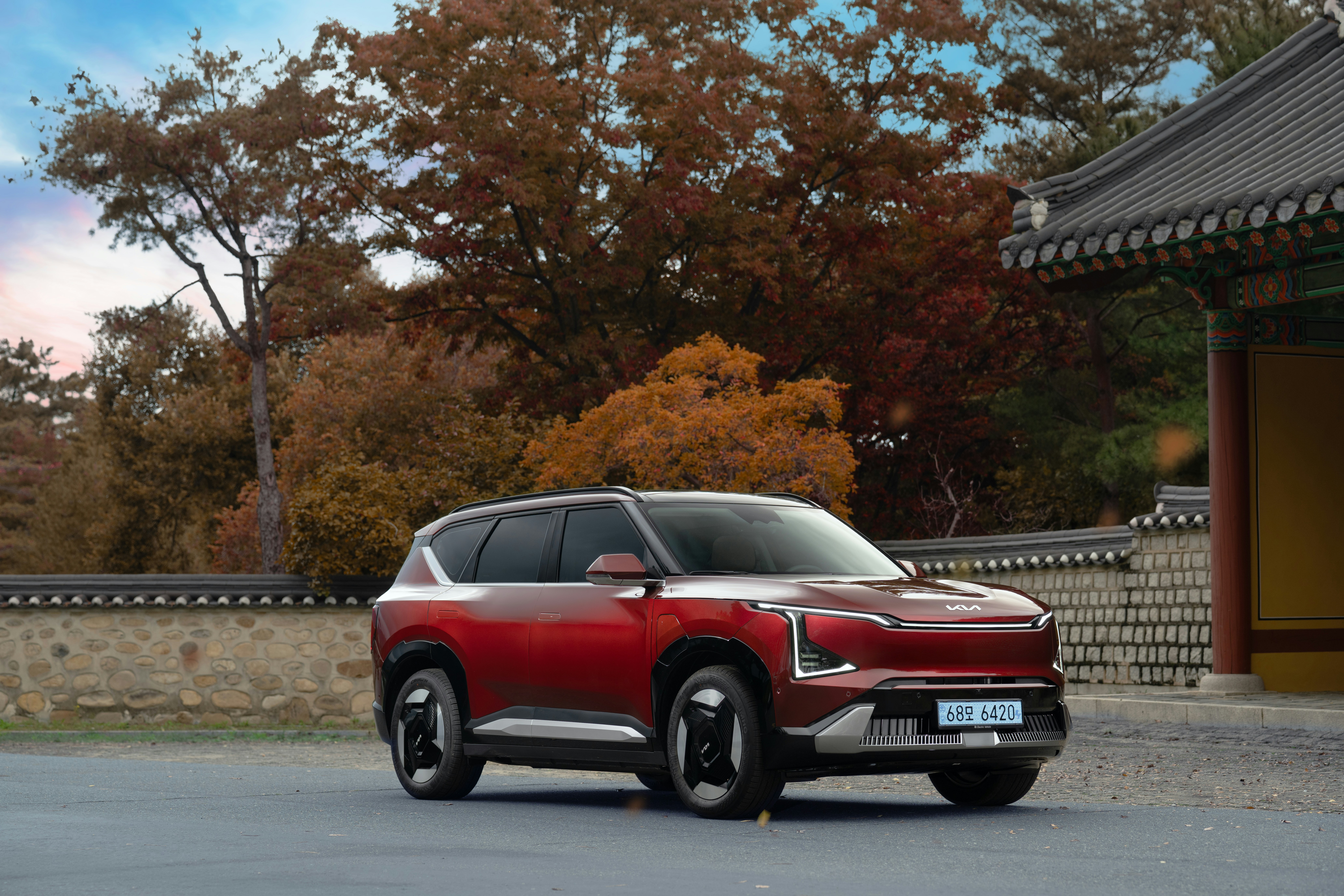 Red electric suv parked near traditional building