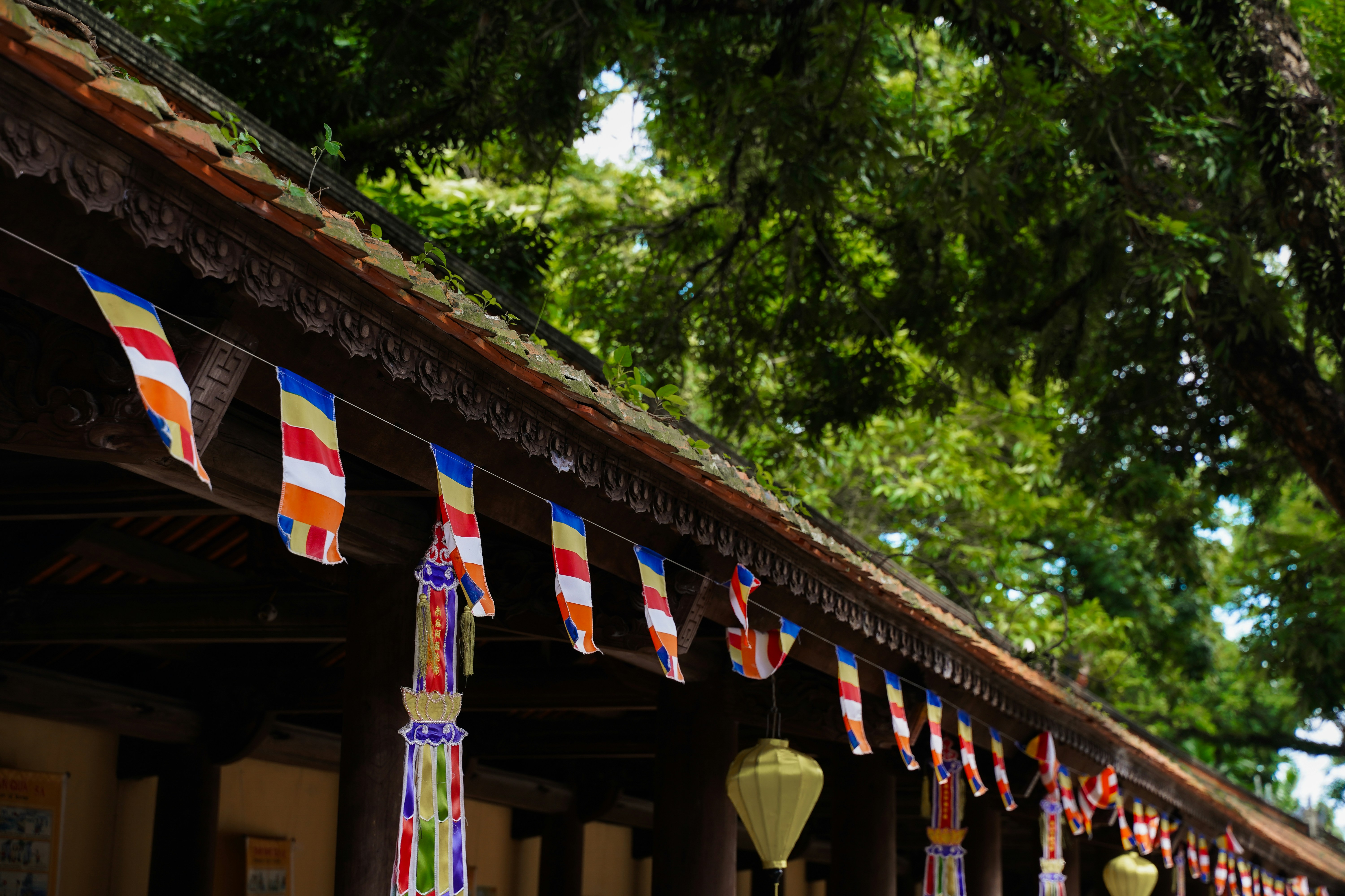 Buddhist prayer flags hang from a temple roof.