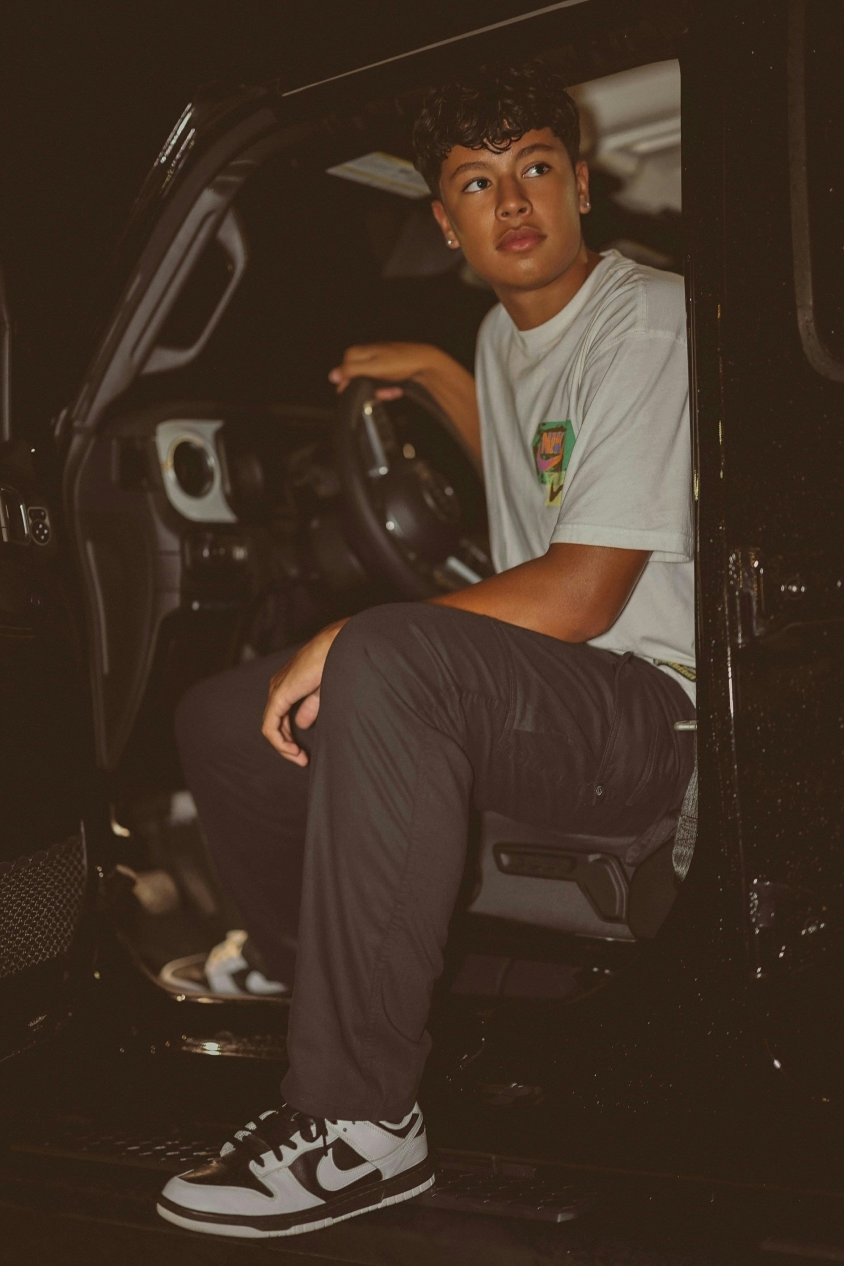 Joven sentado en el asiento del conductor de un automóvil.