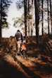 Adult and child hiking through a dry forest.