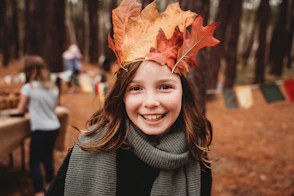 Young girl wearing a crown of autumn leaves