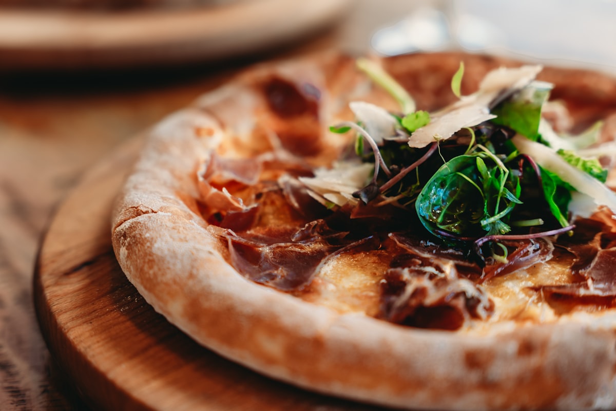 Pizza gastronomique au prosciutto et légumes verts frais
