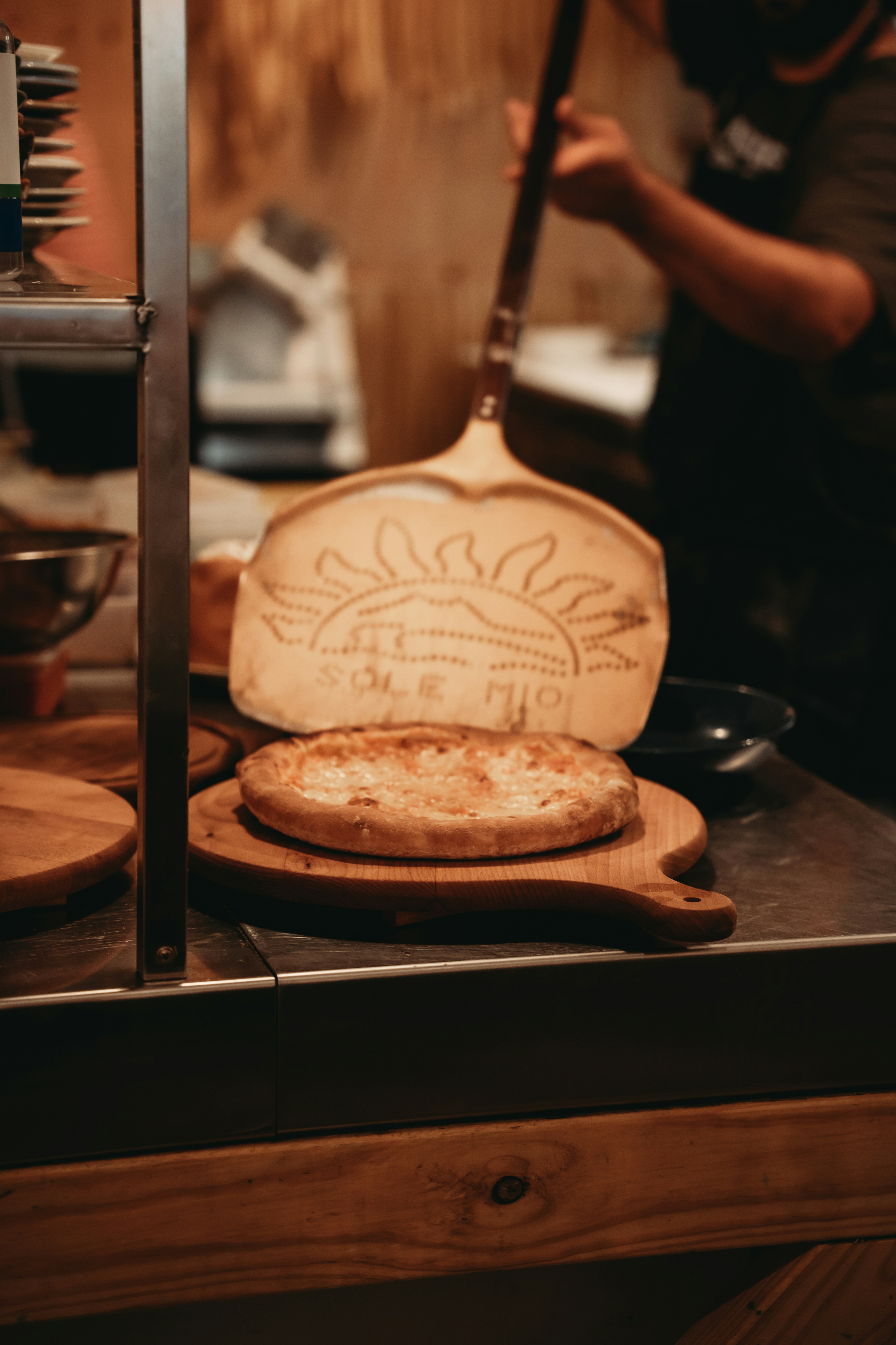 Pizza dough on wooden peel with sun design