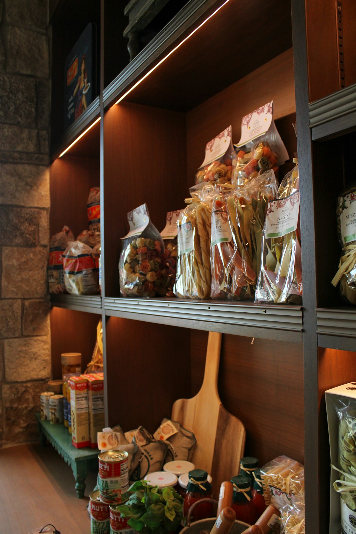 Shelves stocked with bags of dried pasta, tinned goods and jars