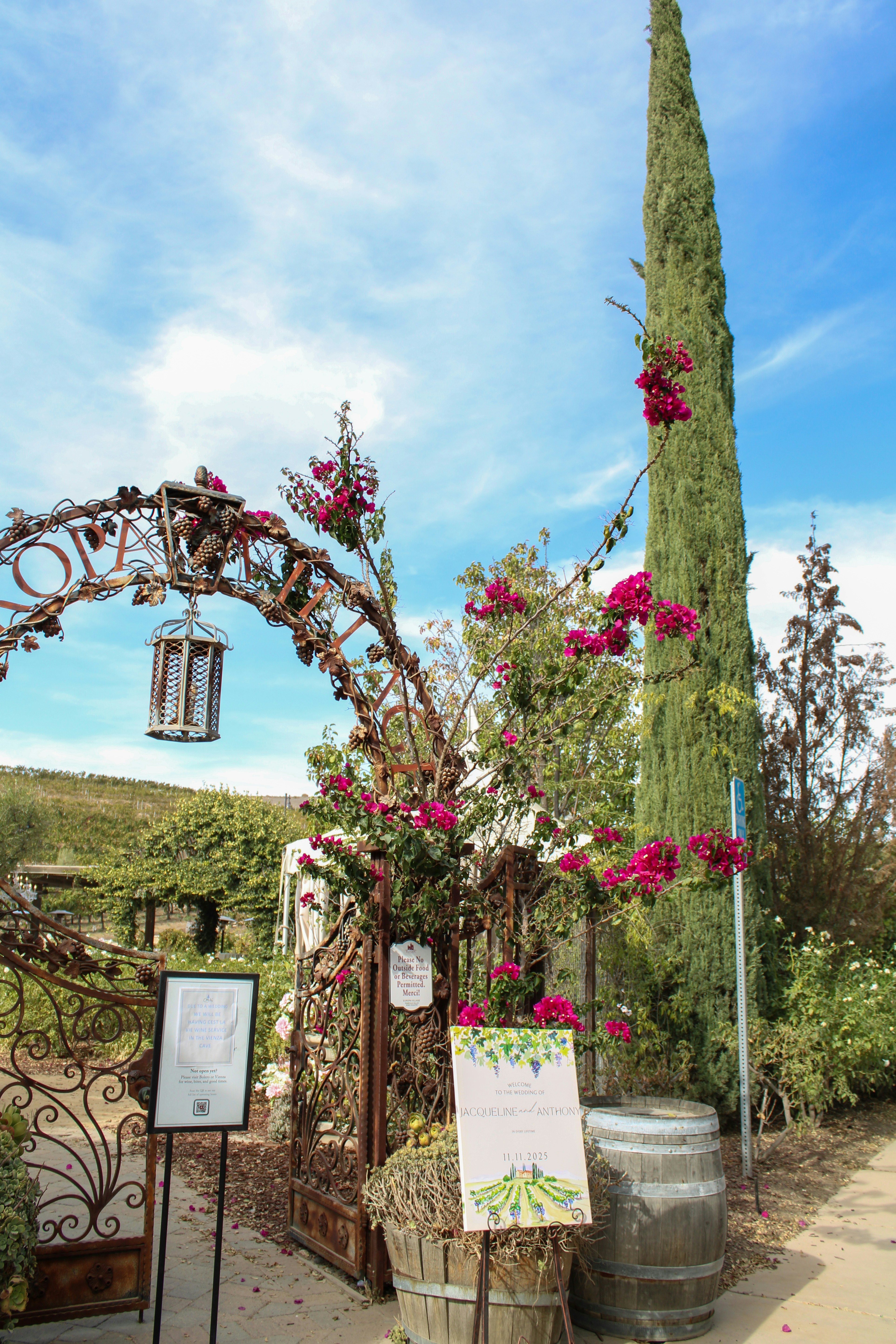 Vineyard entrance with blooming flowers and wine barrel