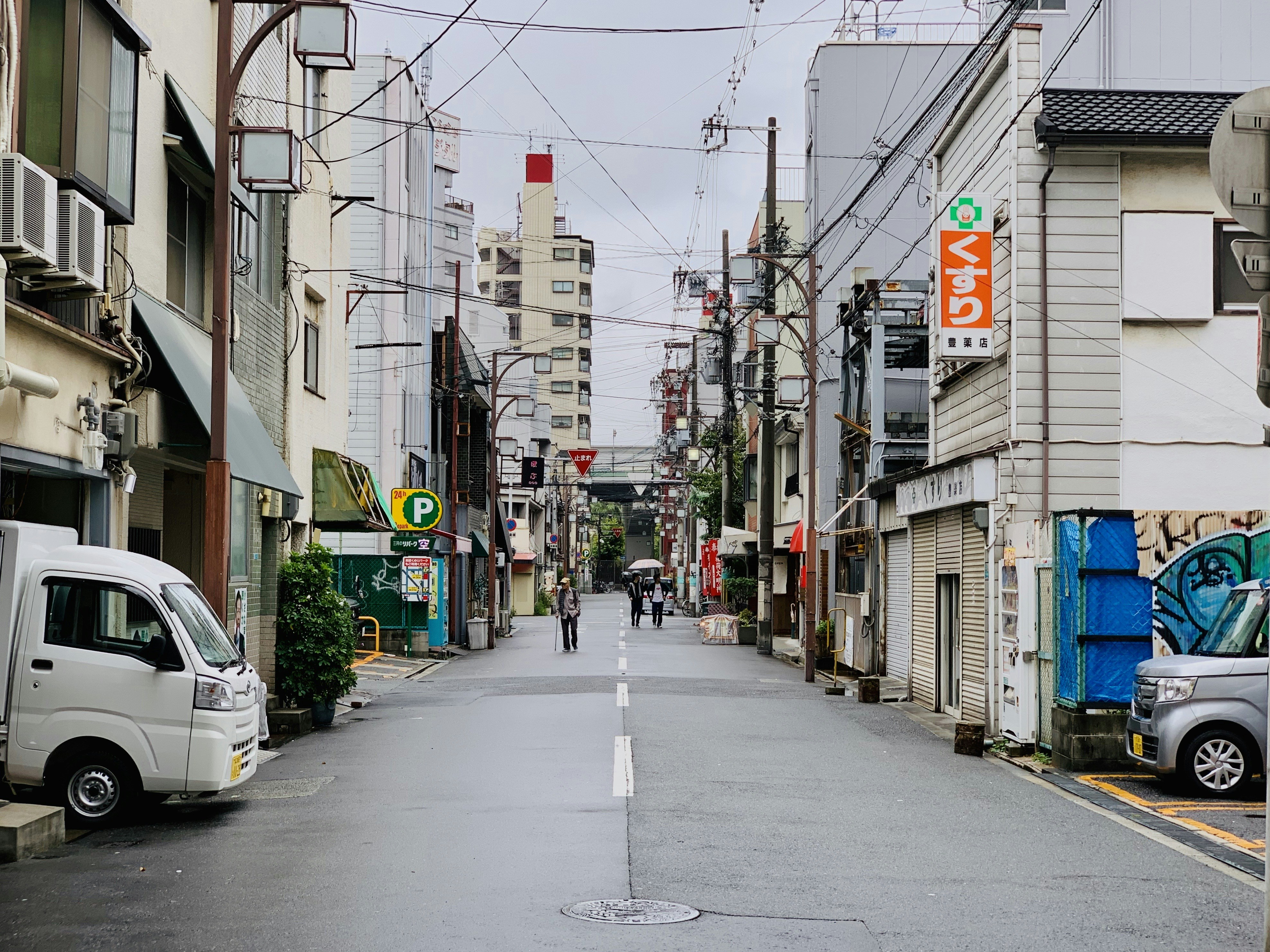 A street in a japanese city with buildings and vehicles.