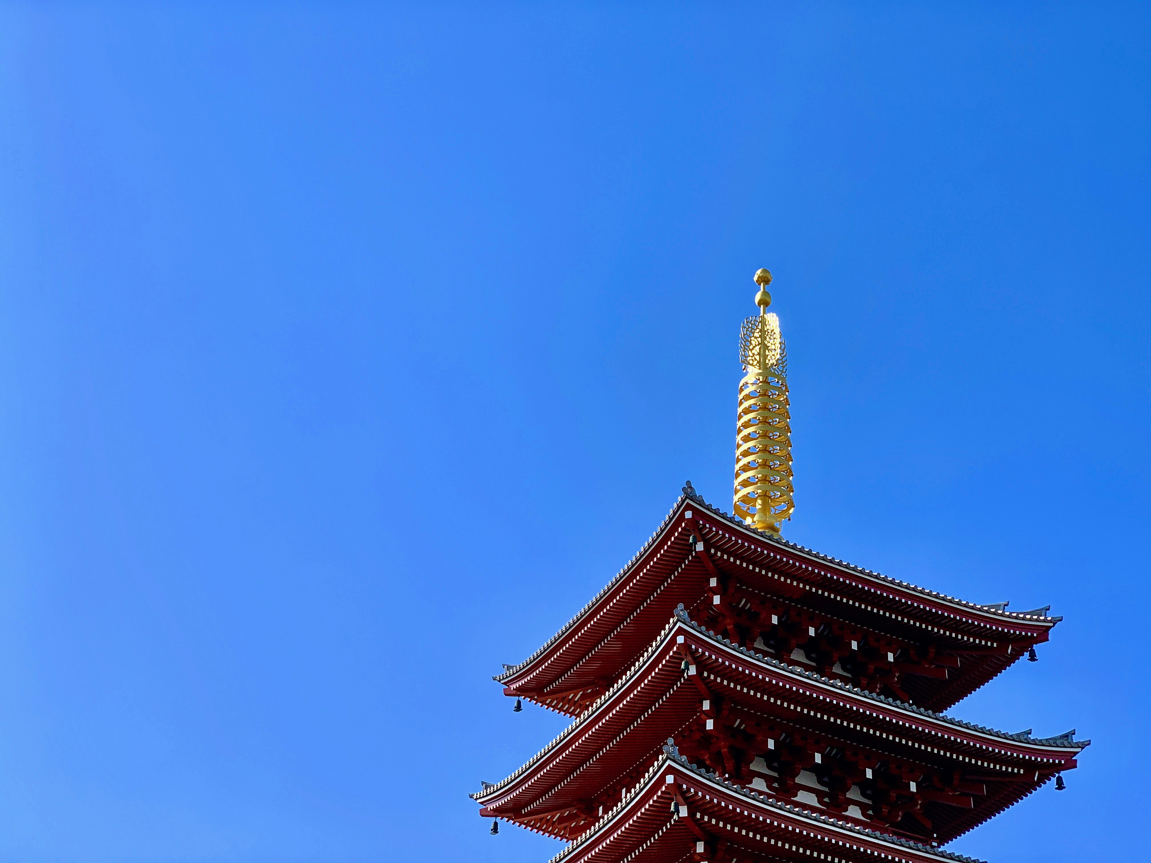 A traditional japanese pagoda against a clear blue sky.