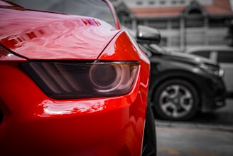 Close-up of a shiny red car's headlight