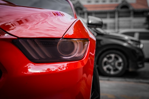 Close-up of a shiny red car's headlight