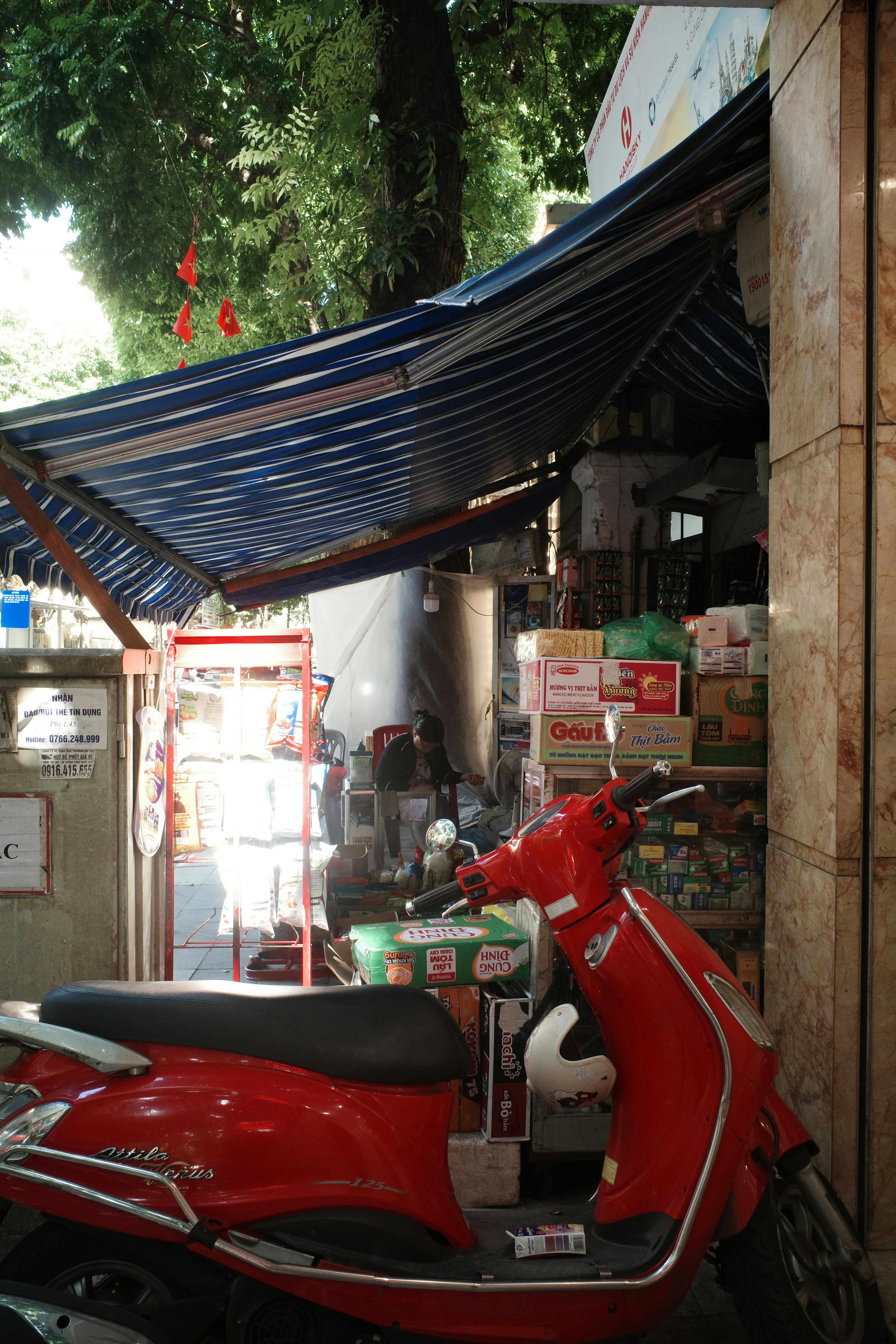 Red scooter parked outside a small store.