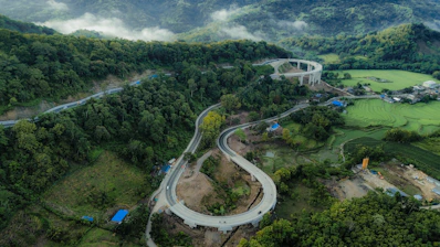 Curving highway winds through lush green mountains.