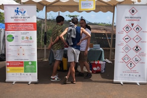 People gathered around information banners at an outdoor event.