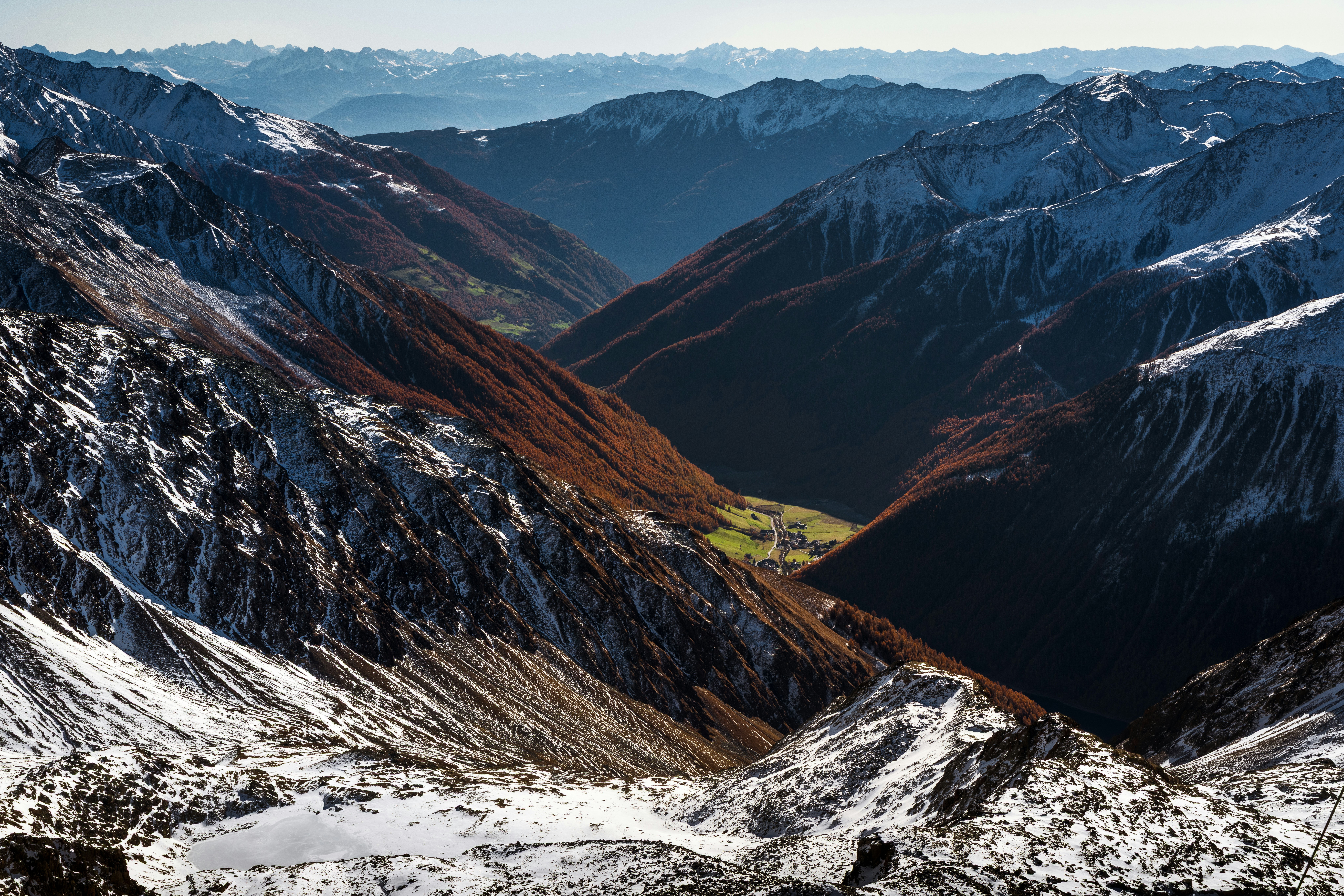 Snow-dusted mountains overlook a green valley below.