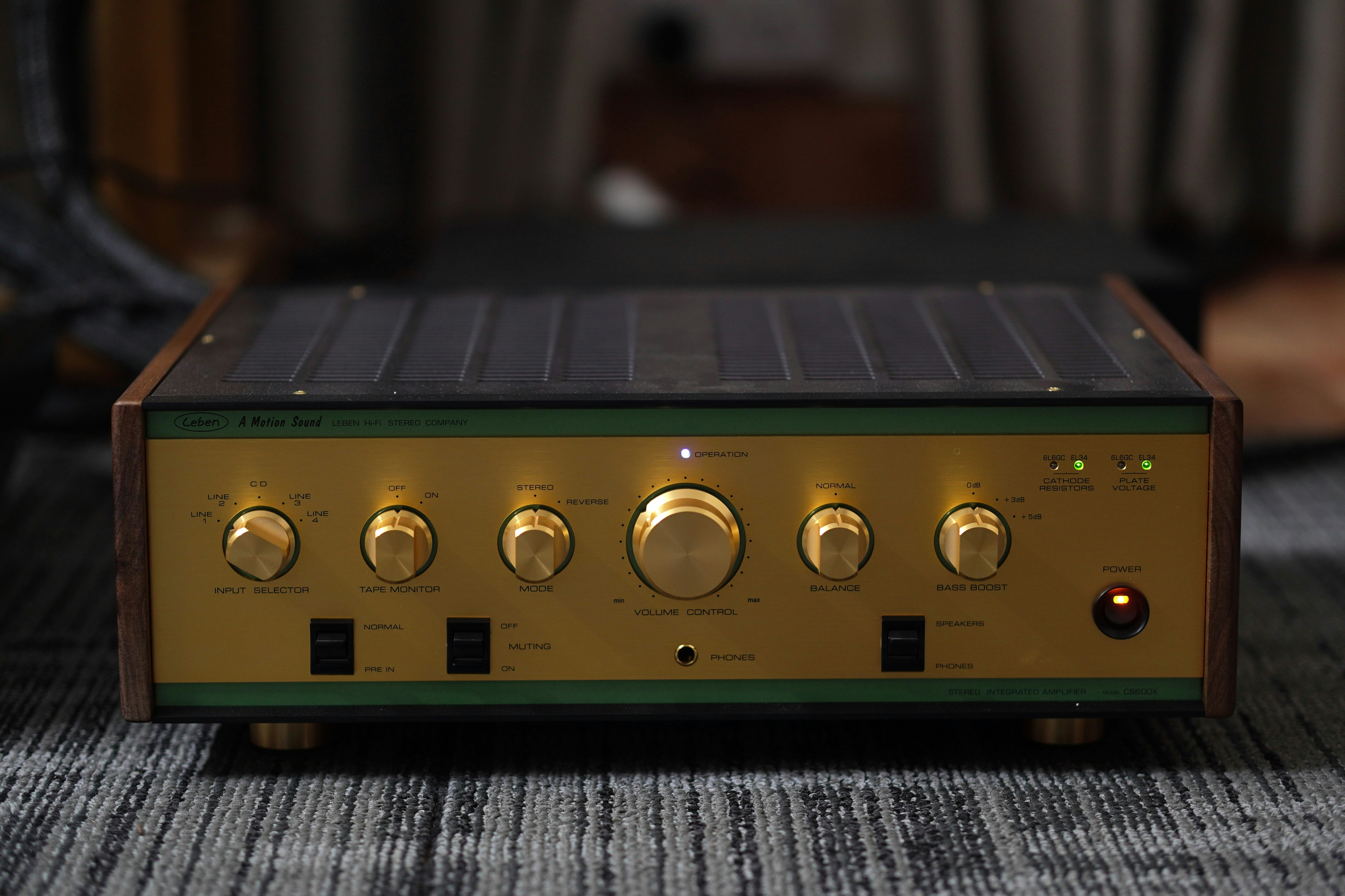Vintage audio amplifier with gold knobs and wooden trim