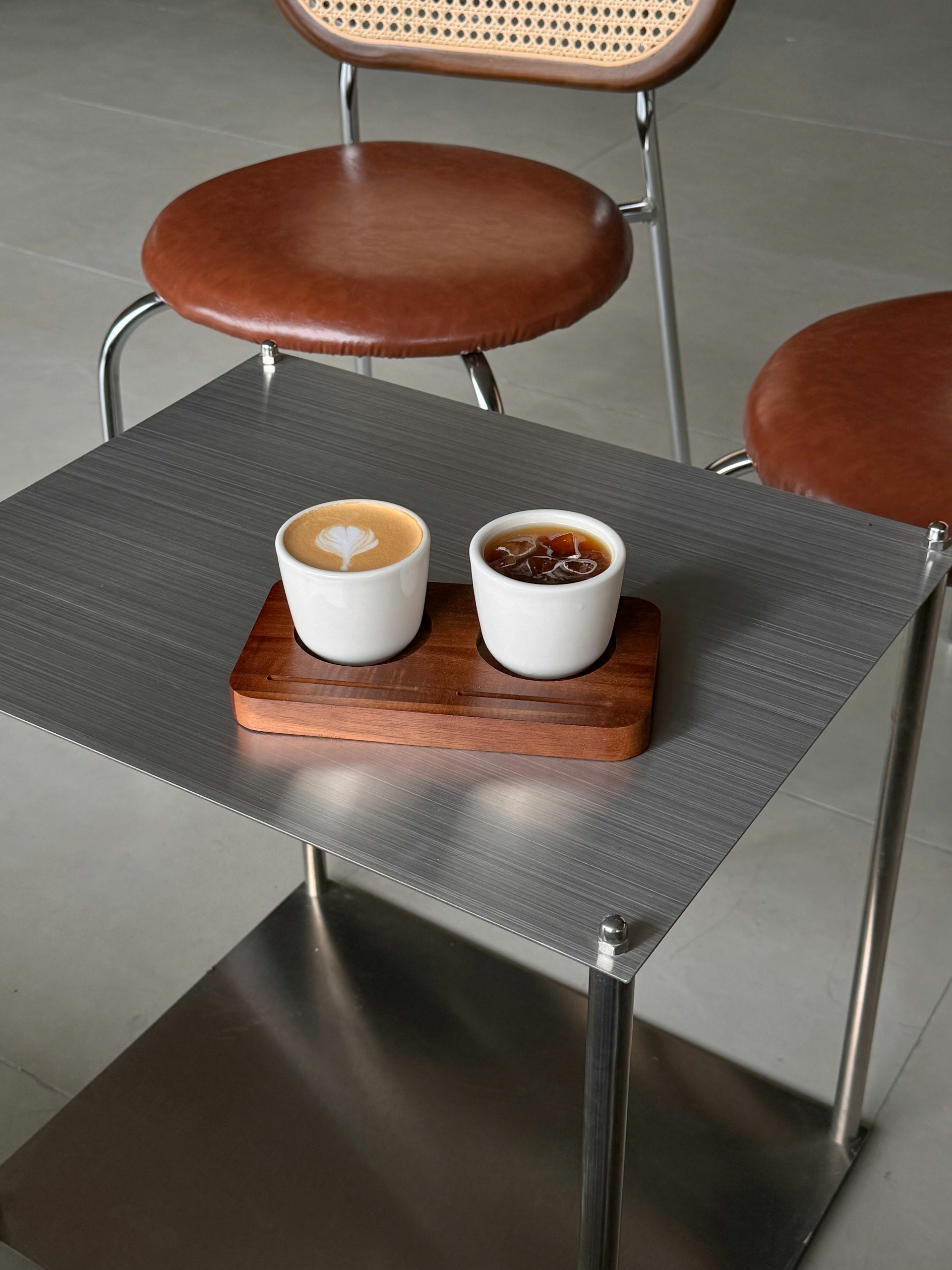Two cups of coffee on a wooden tray