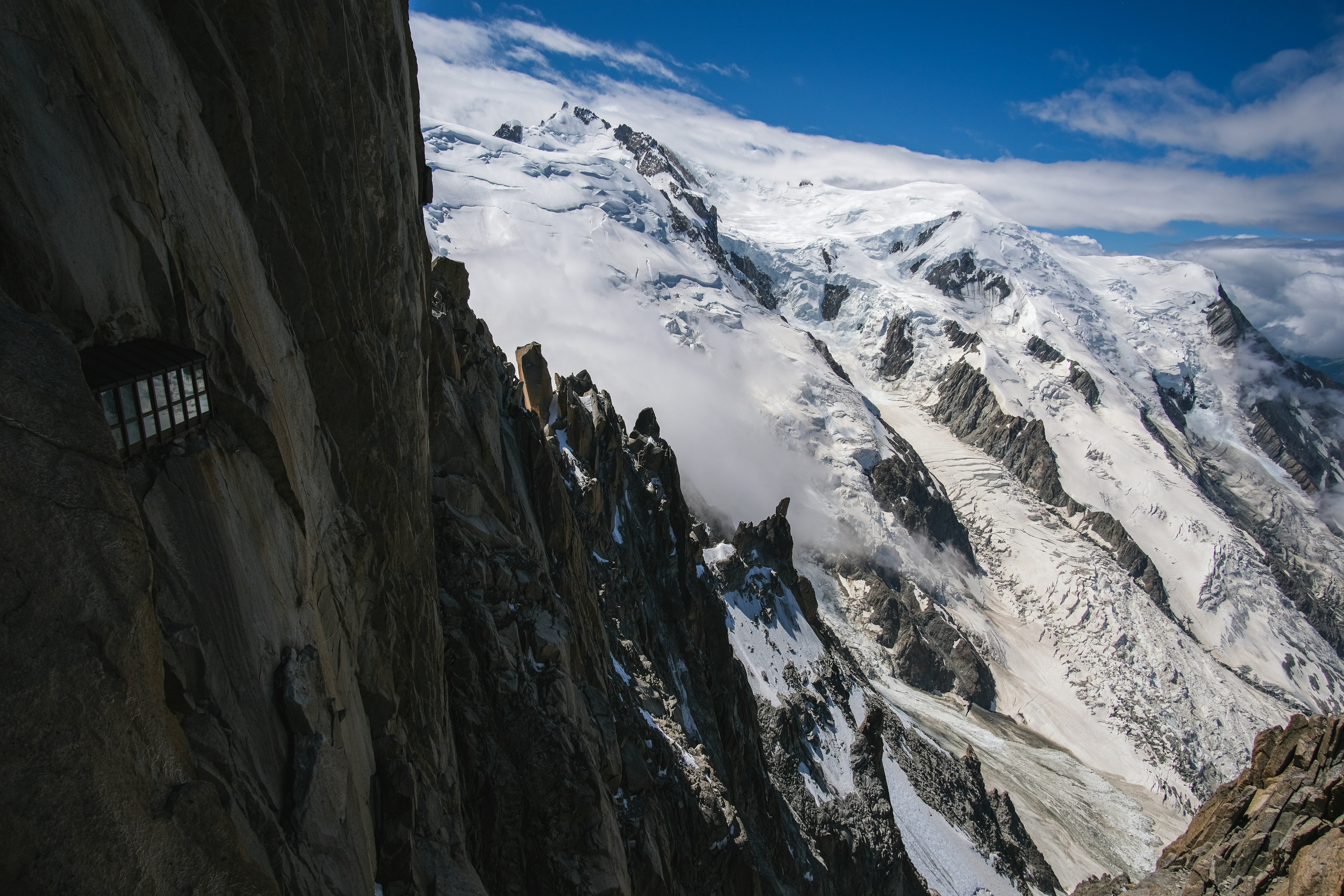 Snow-capped mountains seen from a cliffside