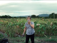 Elderly woman smelling a flower in a field