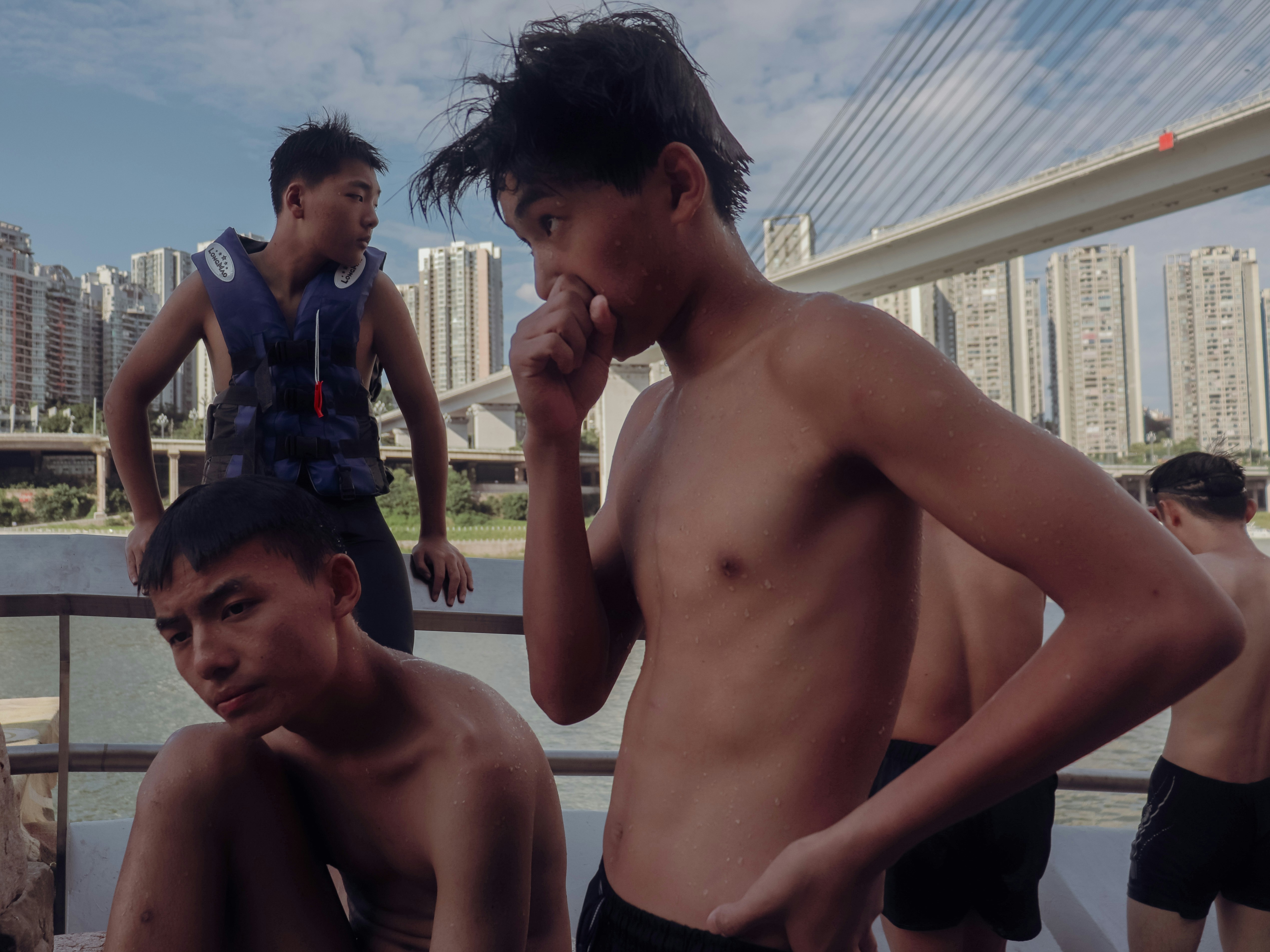 Boys on a boat with city buildings in background