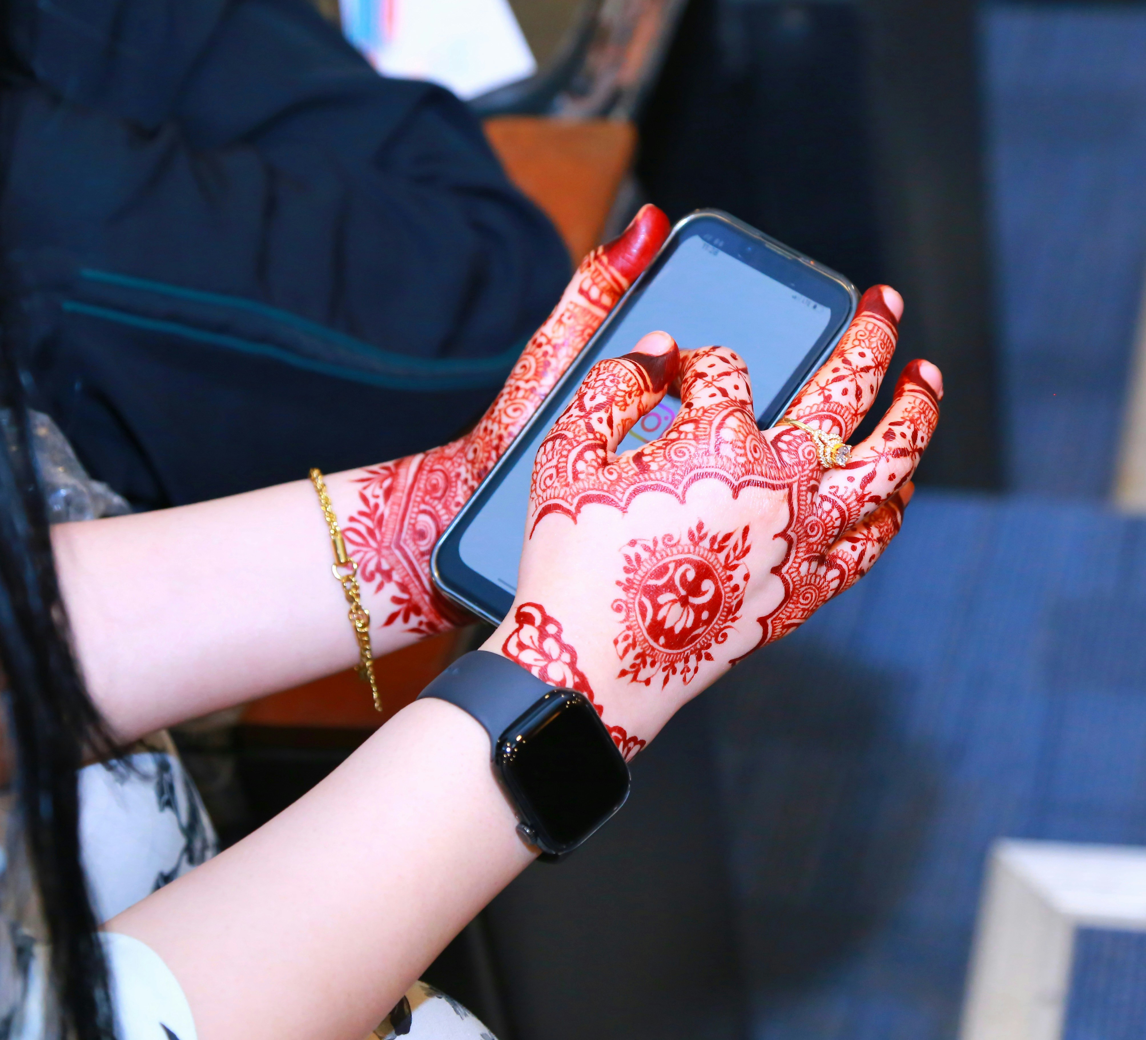 Mãos da mulher com a henna que guarda um smartphone