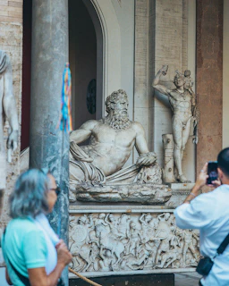 People admire ancient marble statues in a museum
