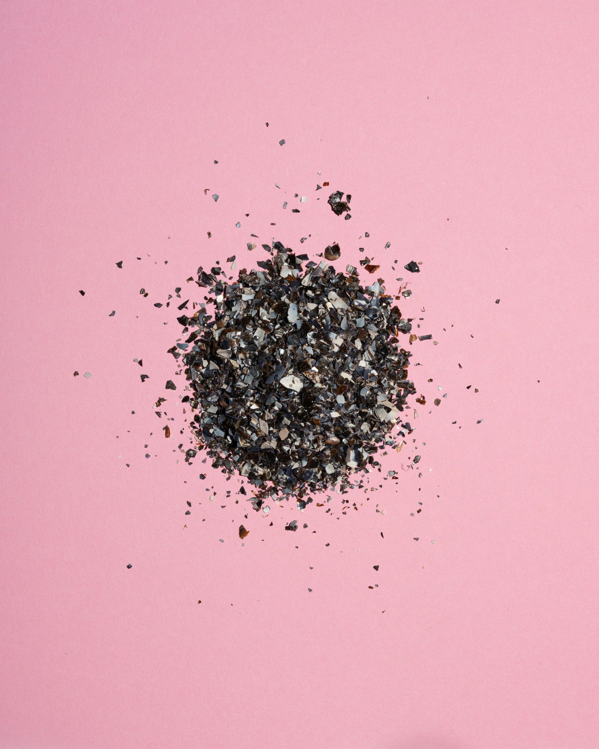 Pile of dark gravel on pink background