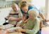 Caregiver assisting elderly couple with coloring