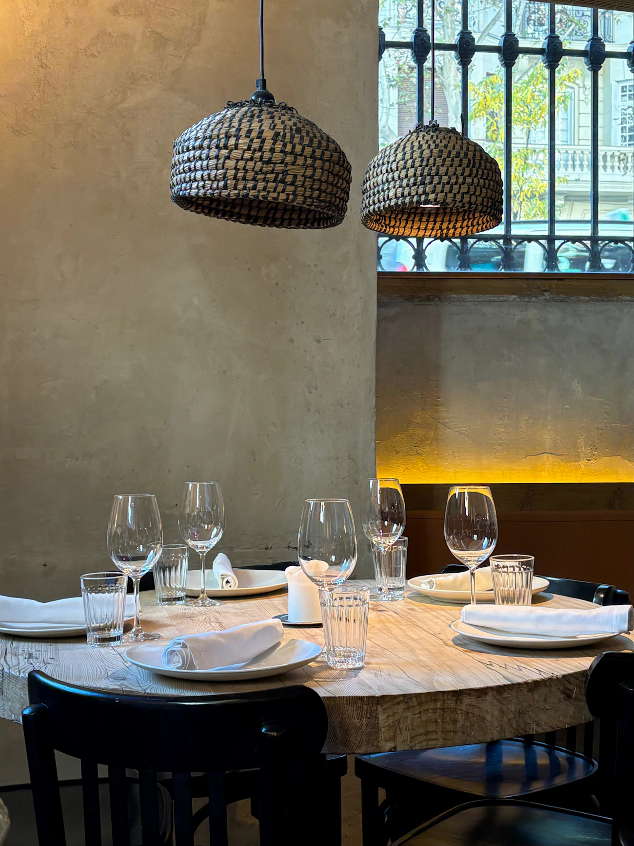 Warmly lit dinner table with wine glasses and a candle